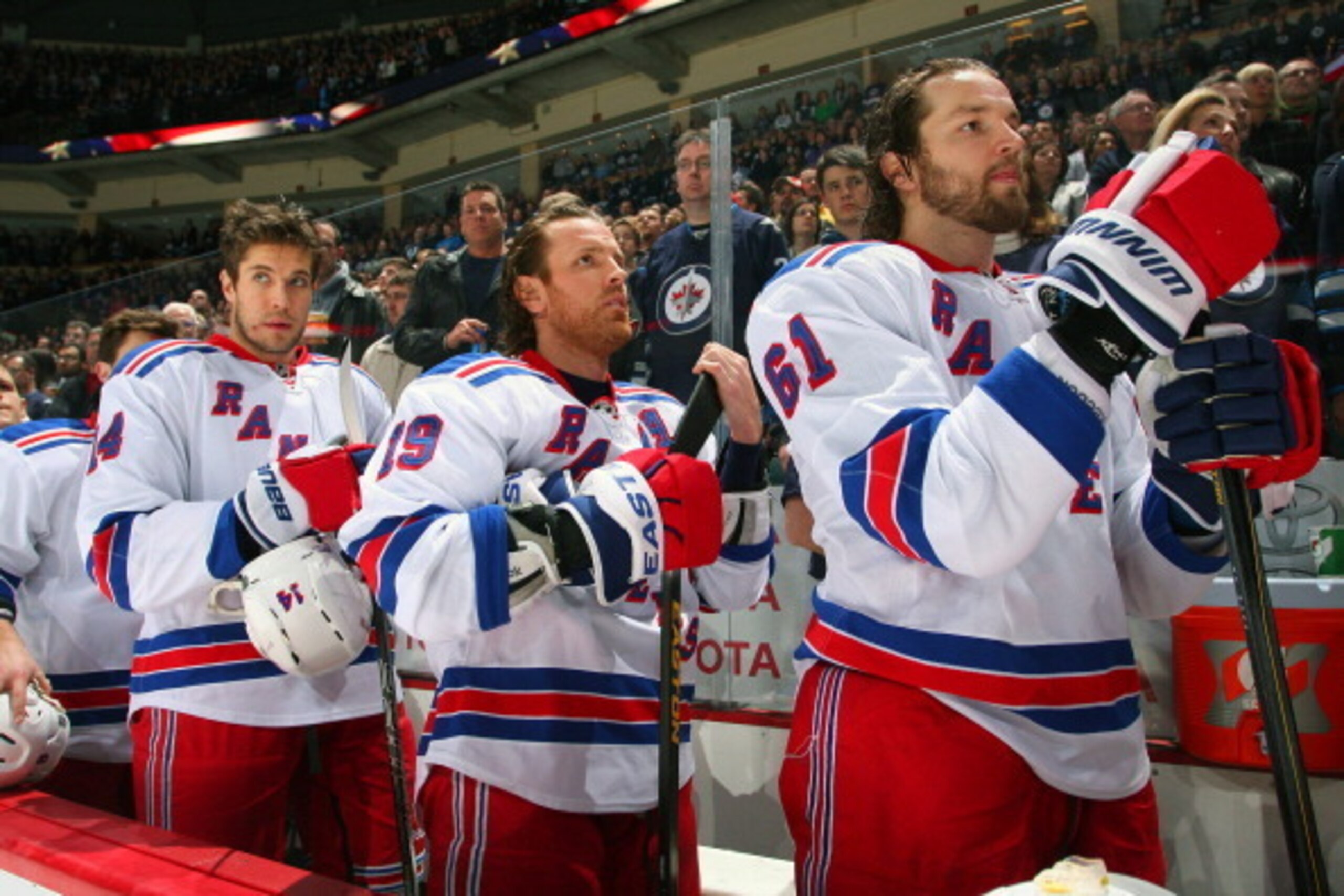WINNIPEG, CANADA - MARCH 14: Taylor Pyatt #14, Brad Richards #19 and Rick Nash #61 of the New York Rangers stand on the bench during the singing of the National anthems prior to puck drop against the Winnipeg Jets at the MTS Centre on March 14, 2013 in Wi