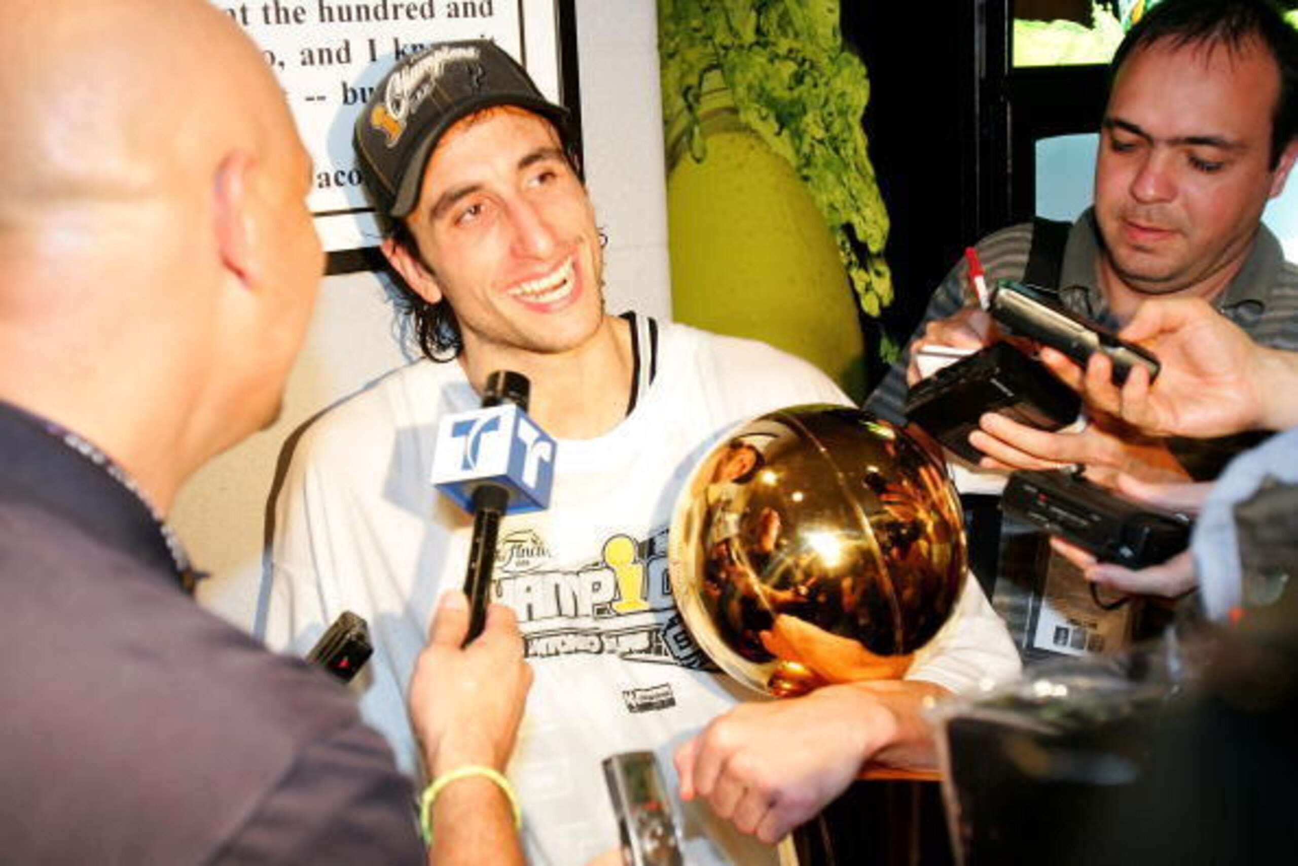 SAN ANTONIO - JUNE 23: Manu Ginobili #20 of the San Antonio Spurs holds the Larry O'Brein NBA Championship trophy as he is interviewed following the Spurs 81-74 win against the Detroit Pistons in Game Seven of the 2005 NBA Finals on June 23, 2005 at SBC C