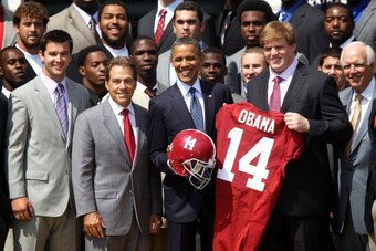 WASHINGTON, DC - APRIL 19:  U.S. President Barack Obama (3rd L) poses for a group picture with members of the University of Alabama Crimson Tide, including coach Nick Saban (2nd L), quarterback A.J. McCarron (L), and offensive lineman Barrett Jones (4th L