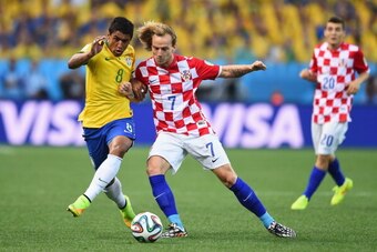 SAO PAULO, BRAZIL - JUNE 12: Ivan Rakitic of Croatia challenges Paulinho of Brazil in the first half during the 2014 FIFA World Cup Brazil Group A match between Brazil and Croatia at Arena de Sao Paulo on June 12, 2014 in Sao Paulo, Brazil.  (Photo by Bud