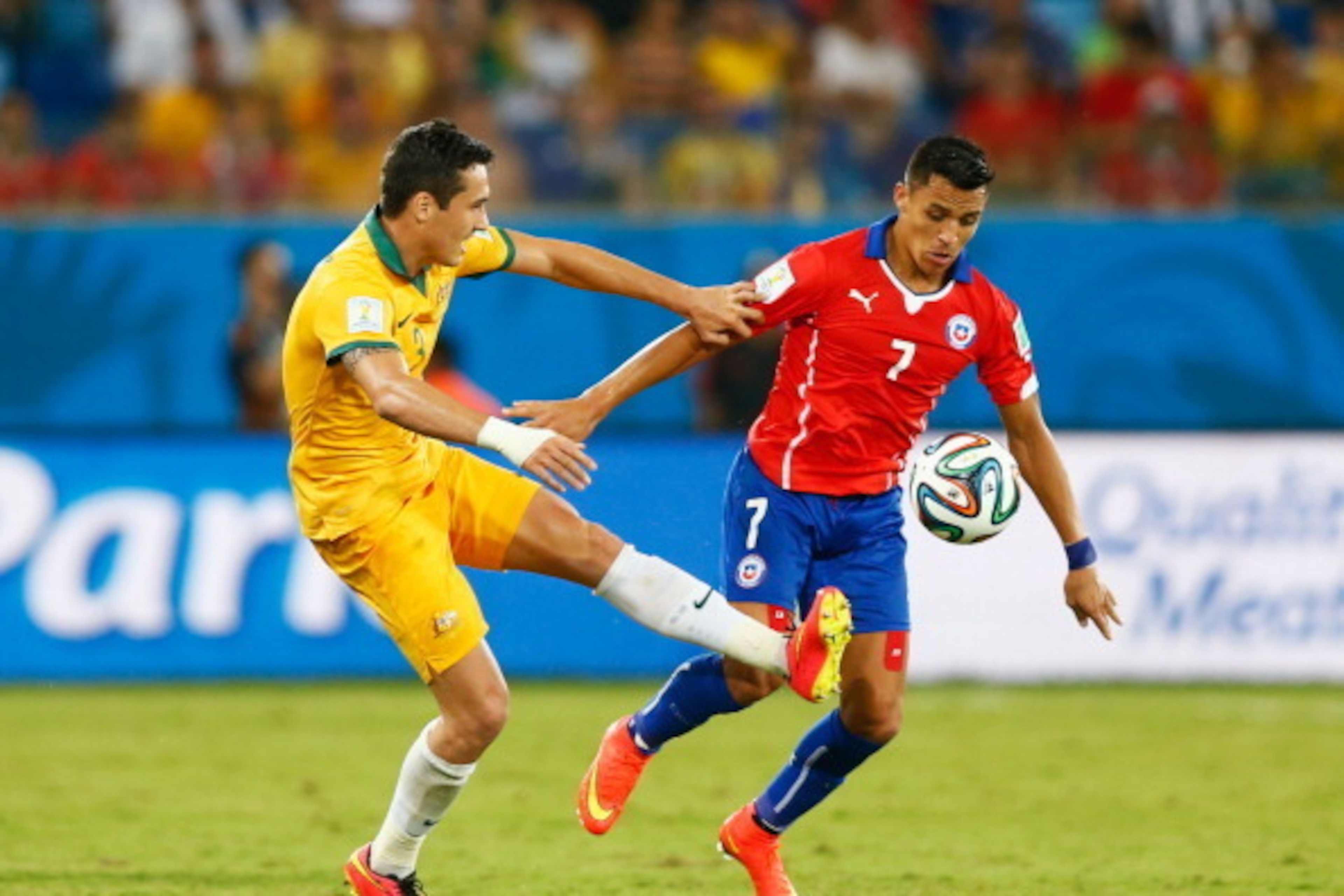 CUIABA, BRAZIL - JUNE 13:  Alexis Sanchez of Chile holds off Jason Davidson of Australia during the 2014 FIFA World Cup Brazil Group B match between Chile and Australia at Arena Pantanal on June 13, 2014 in Cuiaba, Brazil.  (Photo by Phil Walter/Getty Ima