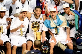 SAN ANTONIO, TX - JUNE 15: Kawhi Leonard #2, Tony Parker #9, Tim Duncan #21, Manu Ginobili #20, and Patty Mills #8 of the San Antonio Spurs celebrate with the Larry O'Brien trophy after defeating the Miami Heat to win the 2014 NBA Finals in Game Five of t