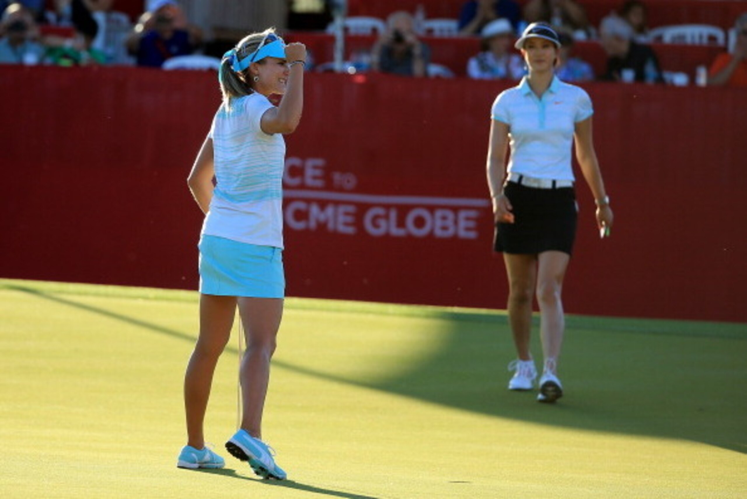 RANCHO MIRAGE, CA - APRIL 06: Lexi Thompson of the USA holes the winning putt as her playing partner Michelle Wie of the USA watches on on the 18th green after her three shot win during the final round of the 2014 Kraft Nabisco Championship on the Dinah RANCHO MIRAGE, CA - APRIL 06: Lexi Thompson of the USA holes the winning putt as her playing partner Michelle Wie of the USA watches on on the 18th green after her three shot win during the final round of the 2014 Kraft Nabisco Championship on the Dinah