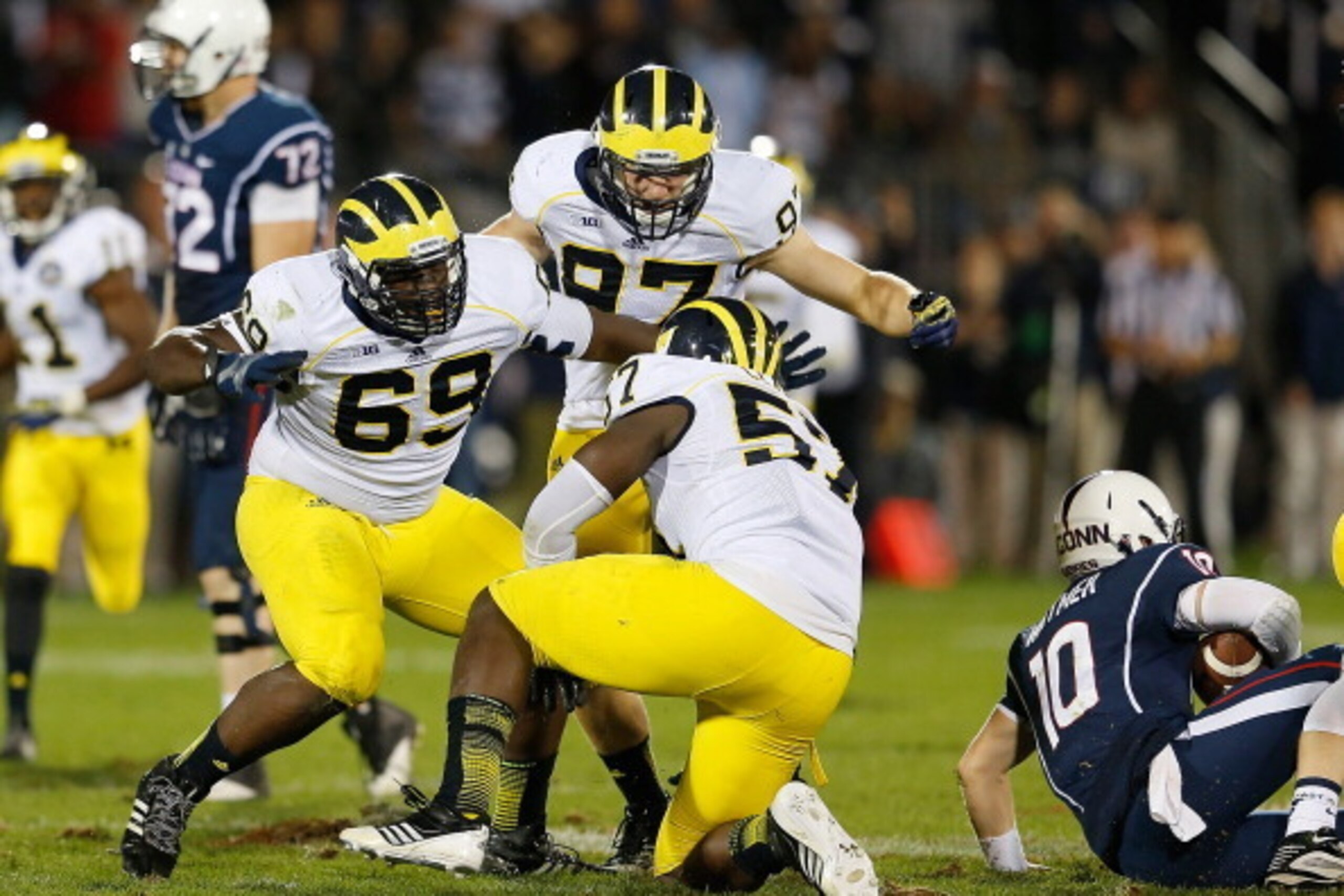 EAST HARTFORD, CT - SEPTEMBER 21: Willie Henry #69, Frank Clark #57 and Brennen Beyer #97 of the Michigan Wolverines celebrate after sacking Chandler Whitmer #10 of the Connecticut Huskies in the second half against the Connecticut Huskies at Rentschler F