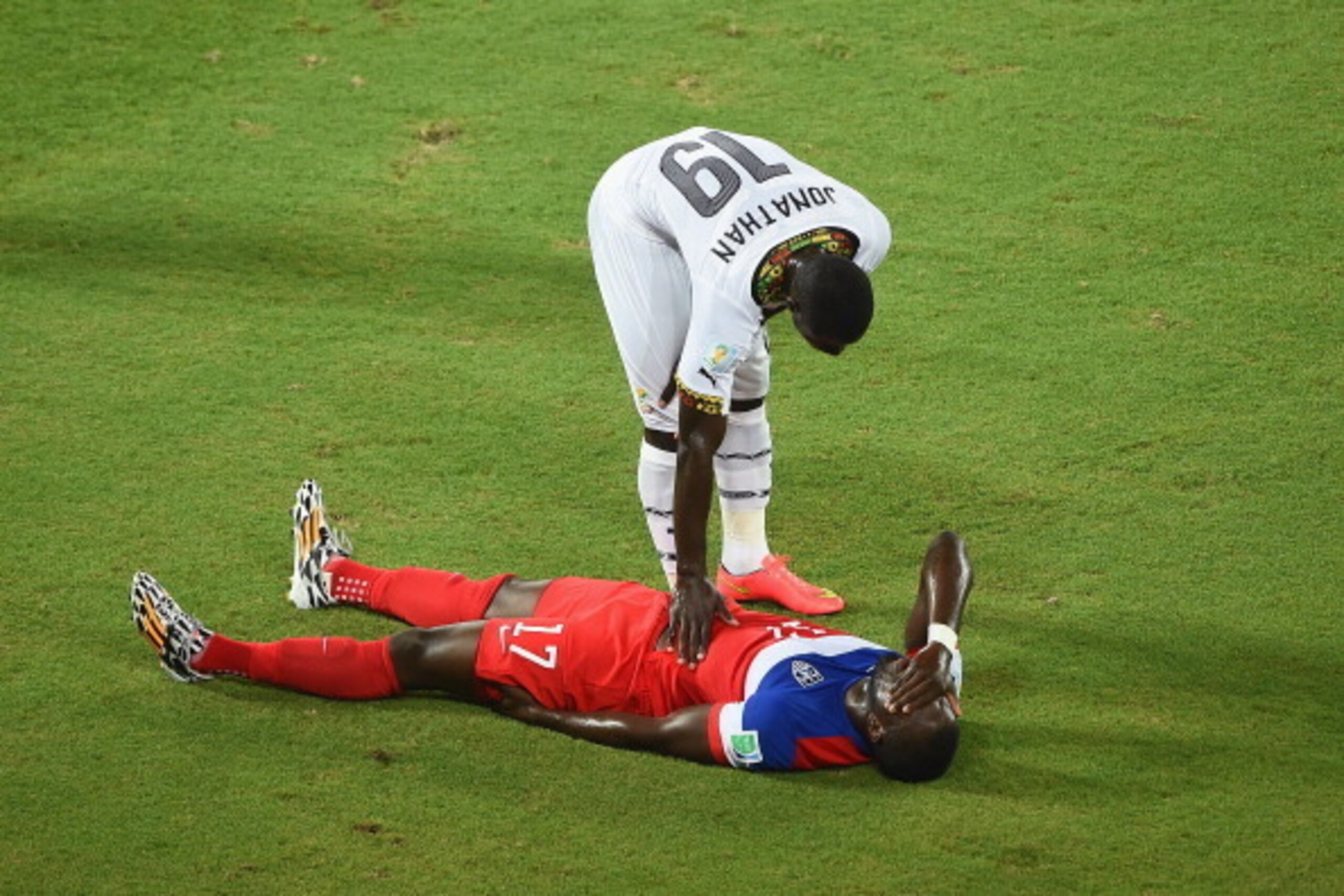 NATAL, BRAZIL - JUNE 16:  Jonathan Mensah of Ghana stands over an injured Jozy Altidore during the 2014 FIFA World Cup Brazil Group G match between Ghana and the United States at Estadio das Dunas on June 16, 2014 in Natal, Brazil.  (Photo by Laurence Gri