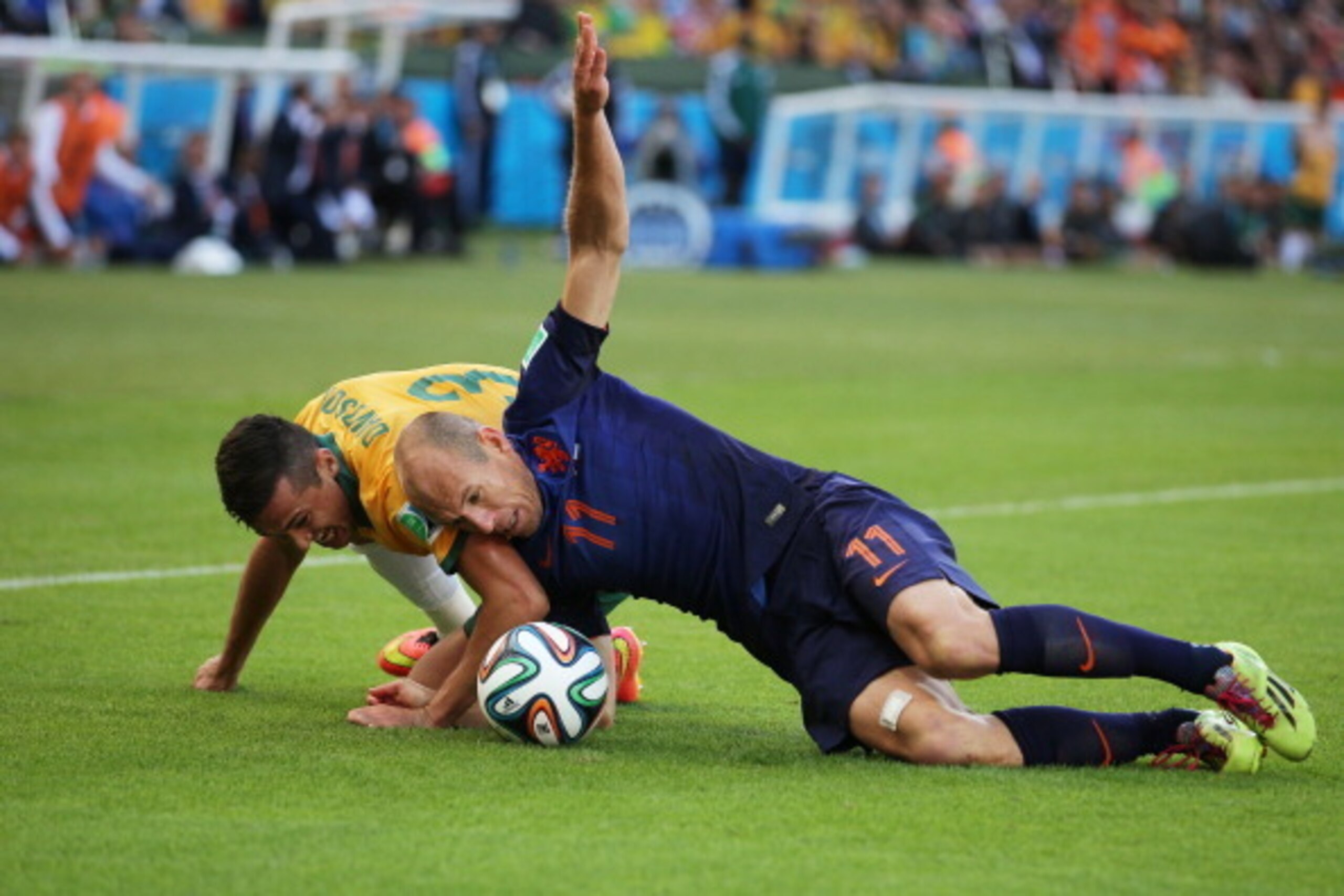 PORTO ALEGRE, BRAZIL - JUNE 18:  Arjen Robben of the Netherlands and Jason Davidson of Australia fall on the pitch during the 2014 FIFA World Cup Brazil Group B match between Australia and Netherlands at Estadio Beira-Rio on June 18, 2014 in Porto Alegre,