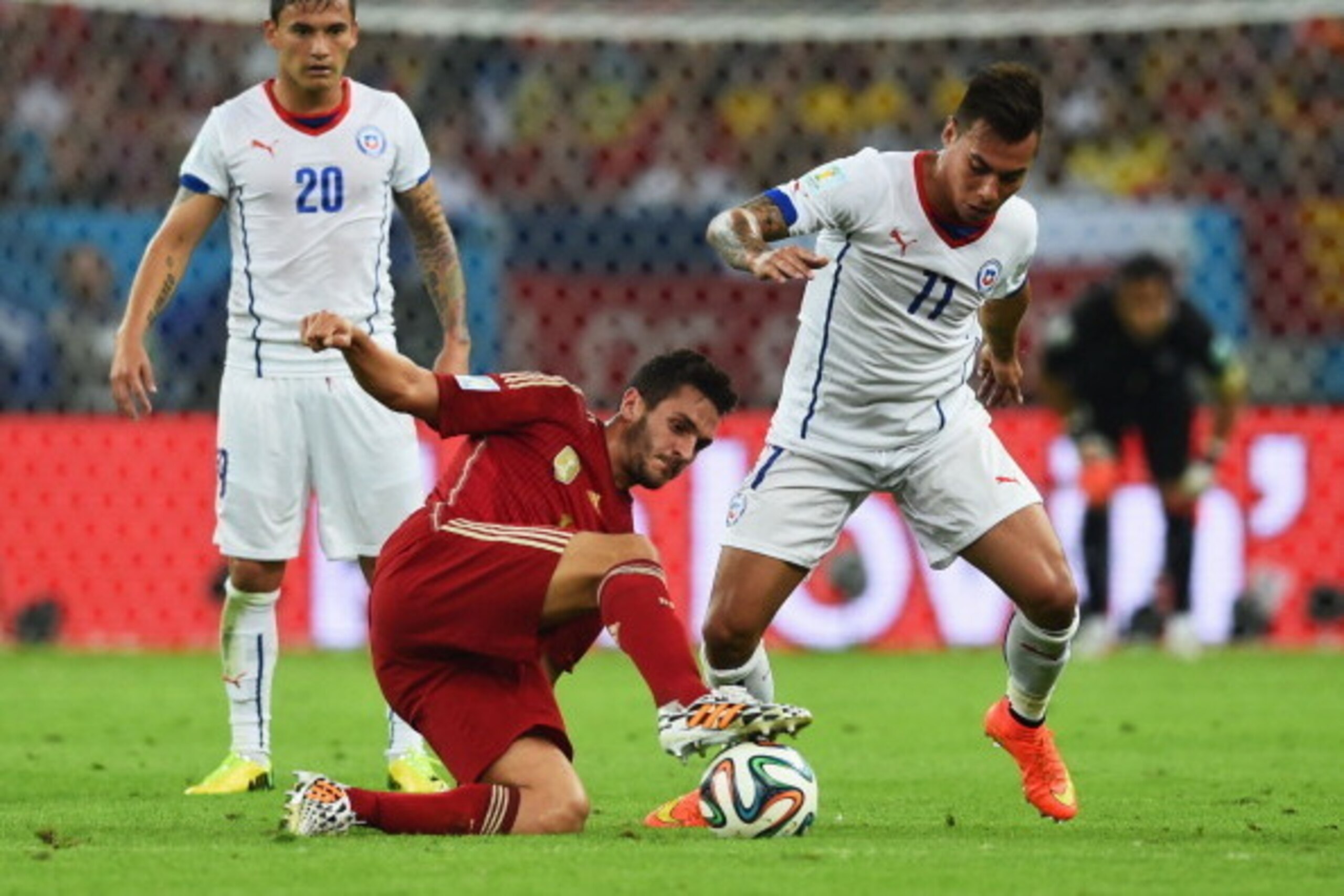 RIO DE JANEIRO, BRAZIL - JUNE 18:  Koke of Spain takes on Charles Aranguiz (L) and Eduardo Vargas of Chile (R) during the 2014 FIFA World Cup Brazil Group B match between Spain and Chile at Maracana on June 18, 2014 in Rio de Janeiro, Brazil.  (Photo by M