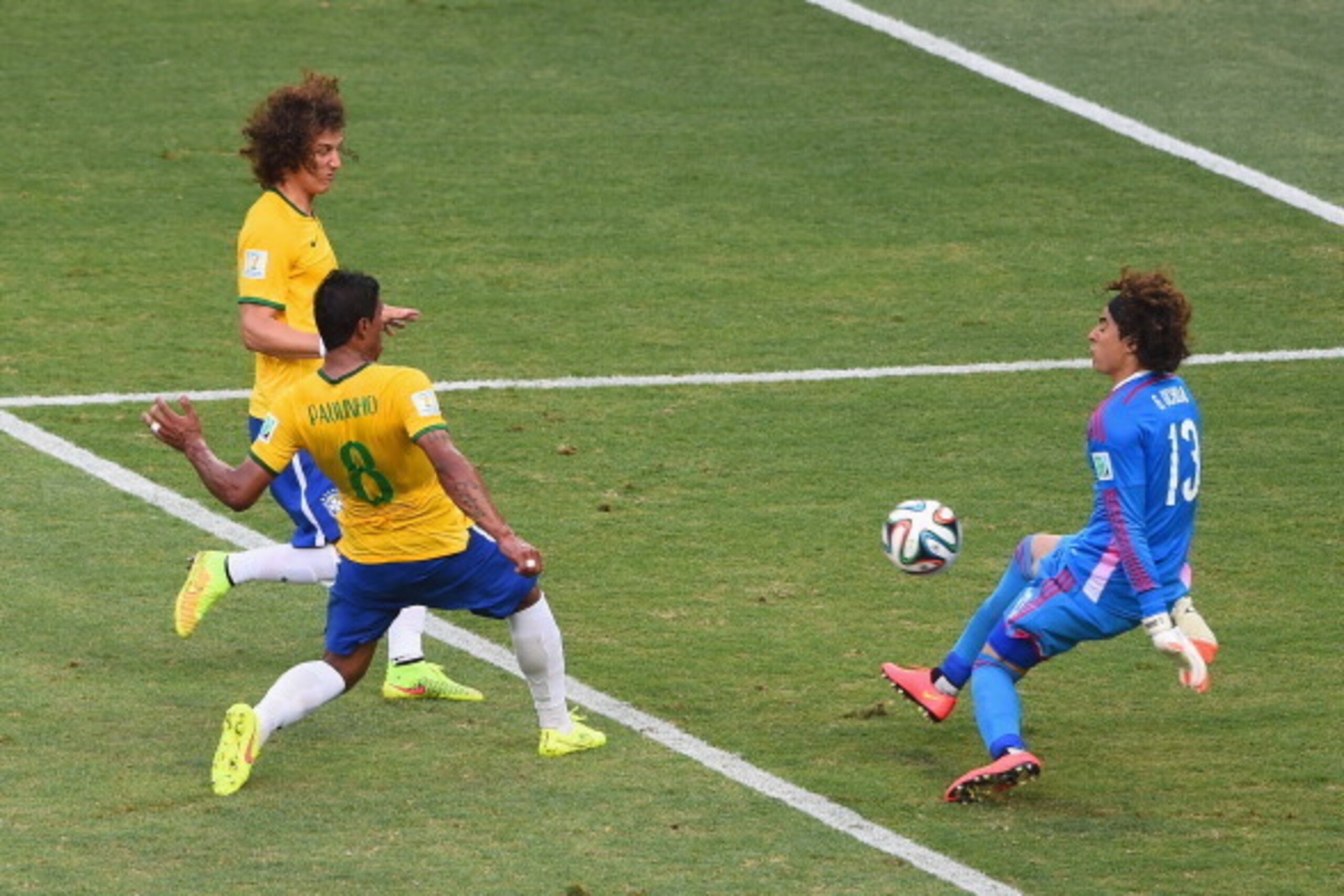 FORTALEZA, BRAZIL - JUNE 17: Paulinho of Brazil shoots against Guillermo Ochoa of Mexico as David Luiz runs on during the 2014 FIFA World Cup Brazil Group A match between Brazil and Mexico at Castelao on June 17, 2014 in Fortaleza, Brazil. (Photo by Jam FORTALEZA, BRAZIL - JUNE 17: Paulinho of Brazil shoots against Guillermo Ochoa of Mexico as David Luiz runs on during the 2014 FIFA World Cup Brazil Group A match between Brazil and Mexico at Castelao on June 17, 2014 in Fortaleza, Brazil. (Photo by Jam