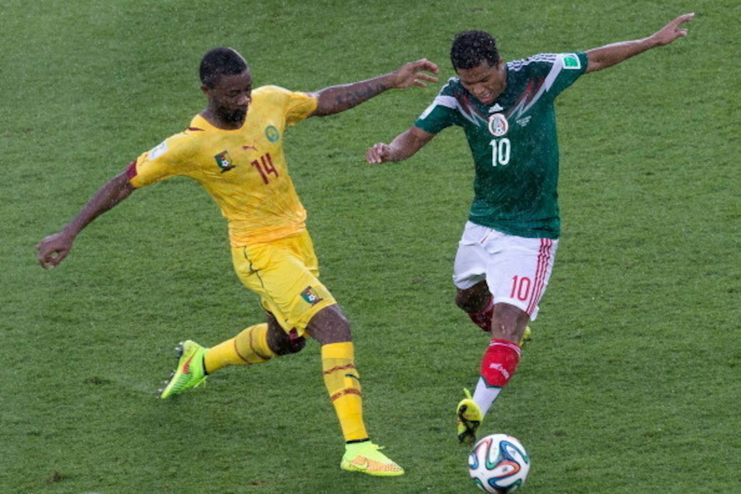 NATAL, BRAZIL - JUNE 13: Aurelien Chedjou of Cameroon battles with Giovani dos Santos of Mexico during the 2014 FIFA World Cup Brazil Group A match between Mexico and Cameroon at Estadio das Dunas on June 13, 2014 in Natal, Brazil. (Photo by Miguel Tov NATAL, BRAZIL - JUNE 13: Aurelien Chedjou of Cameroon battles with Giovani dos Santos of Mexico during the 2014 FIFA World Cup Brazil Group A match between Mexico and Cameroon at Estadio das Dunas on June 13, 2014 in Natal, Brazil. (Photo by Miguel Tov