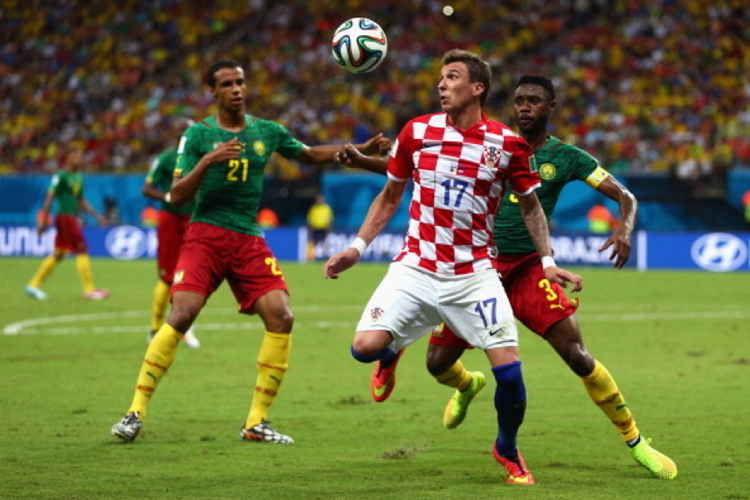 MANAUS, BRAZIL - JUNE 18:  Mario Mandzukic of Croatia controls the ball as Nicolas N'Koulou and Joel Matip of Cameroon give chase during the 2014 FIFA World Cup Brazil Group A match between Cameroon and Croatia at Arena Amazonia on June 18, 2014 in Manaus