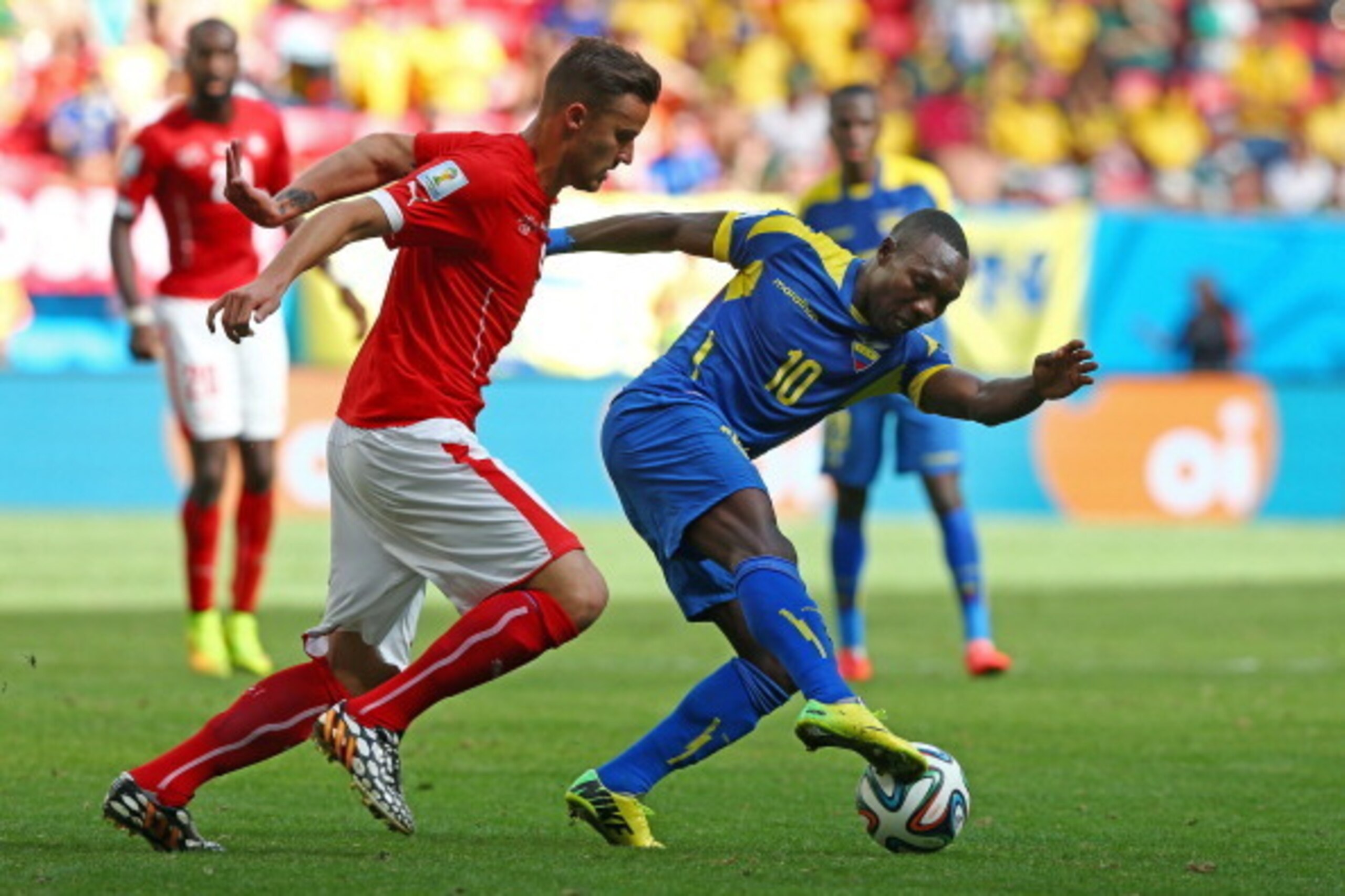 BRASILIA, BRAZIL - JUNE 15:  Walter Ayovi of Ecuador dribbles past Haris Seferovic of Switzerland during the 2014 FIFA World Cup Brazil Group E match between Switzerland and Ecuador at Estadio Nacional on June 15, 2014 in Brasilia, Brazil.  (Photo by Cliv