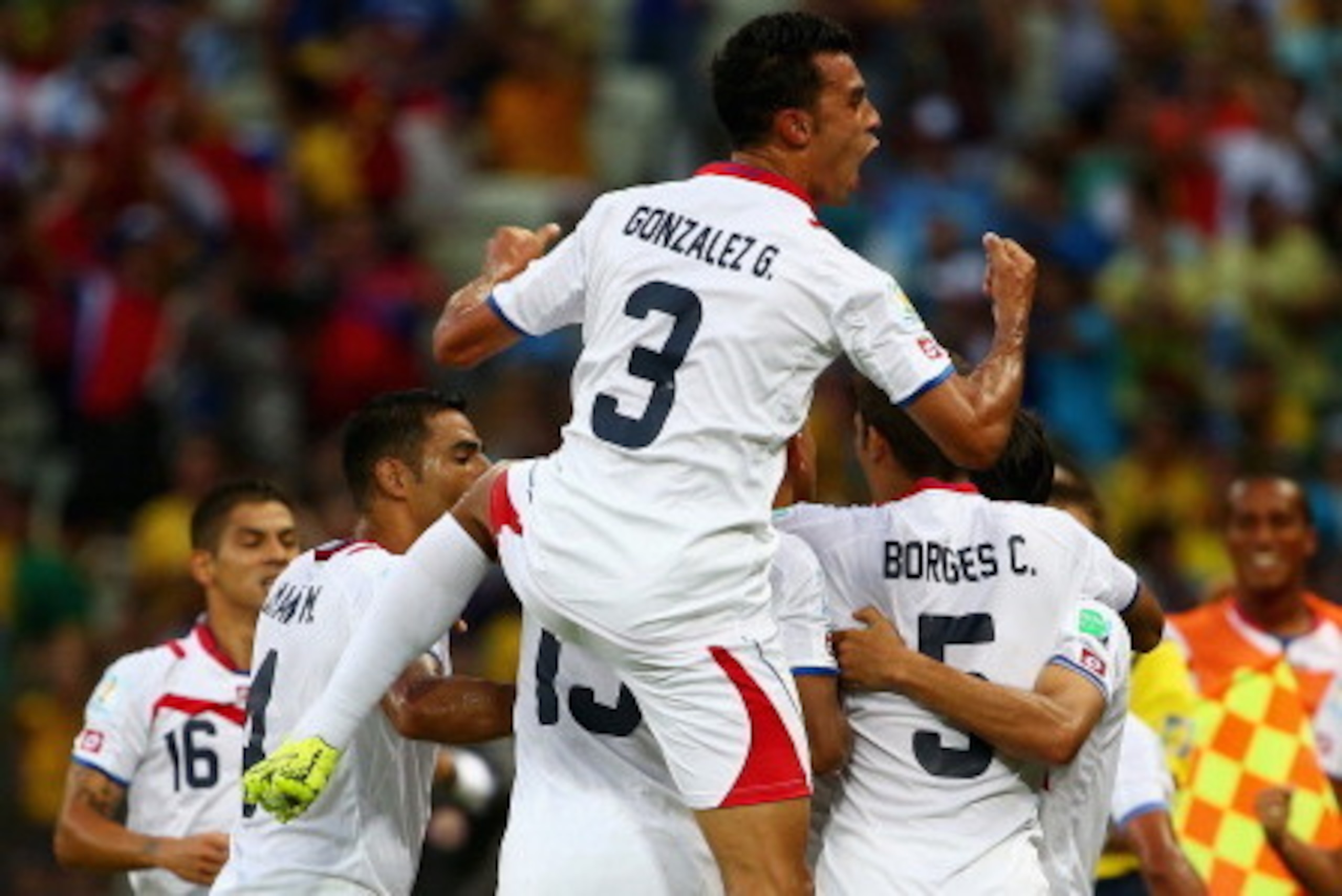 FORTALEZA, BRAZIL - JUNE 14:  Giancarlo Gonzalez of Costa Rica jumps on his teammates as they celebrate the team's second goal by Oscar Duarte (obscured) during the 2014 FIFA World Cup Brazil Group D match between Uruguay and Costa Rica at Castelao on Jun