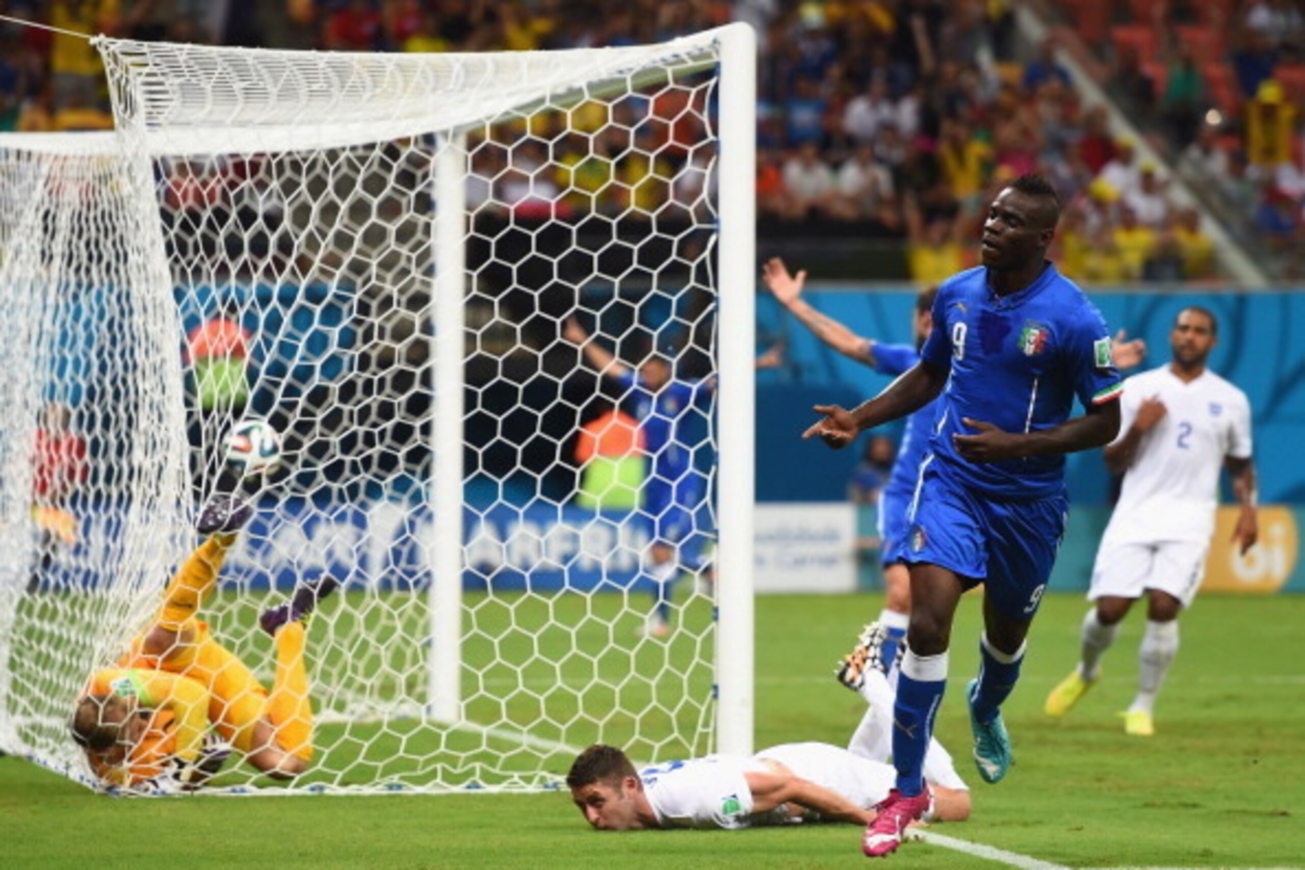 MANAUS, BRAZIL - JUNE 14: Mario Balotelli of Italy celebrates after scoring his team's second goal on a header past Gary Cahill (C) and goalkeeper Joe Hart of England during the 2014 FIFA World Cup Brazil Group D match between England and Italy at Arena MANAUS, BRAZIL - JUNE 14: Mario Balotelli of Italy celebrates after scoring his team's second goal on a header past Gary Cahill (C) and goalkeeper Joe Hart of England during the 2014 FIFA World Cup Brazil Group D match between England and Italy at Arena