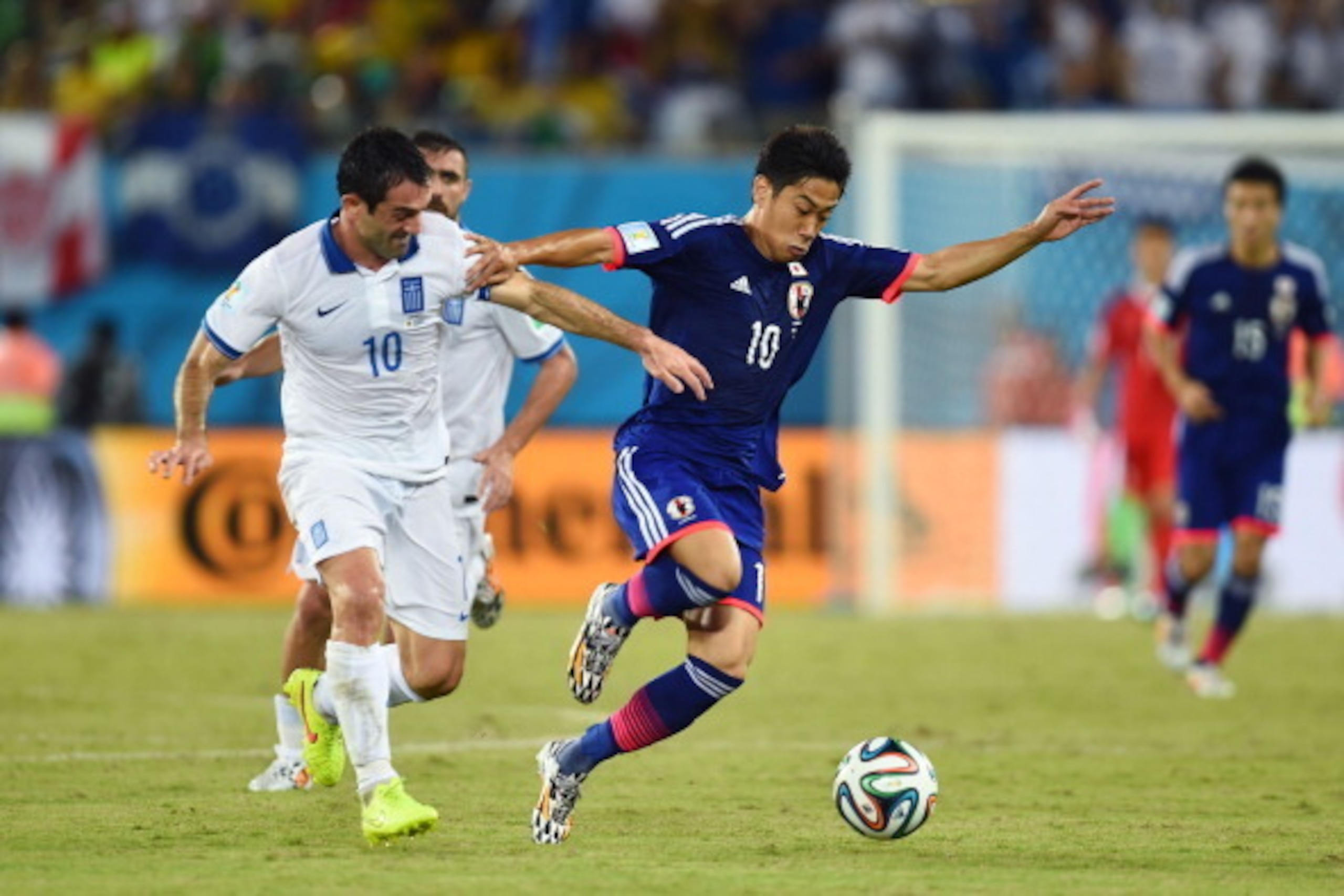 NATAL, BRAZIL - JUNE 19: Giorgos Karagounis of Greece challenges Shinji Kagawa of Japan during the 2014 FIFA World Cup Brazil Group C match between Japan and Greece at Estadio das Dunas on June 19, 2014 in Natal, Brazil. (Photo by Jamie McDonald/Getty NATAL, BRAZIL - JUNE 19: Giorgos Karagounis of Greece challenges Shinji Kagawa of Japan during the 2014 FIFA World Cup Brazil Group C match between Japan and Greece at Estadio das Dunas on June 19, 2014 in Natal, Brazil. (Photo by Jamie McDonald/Getty