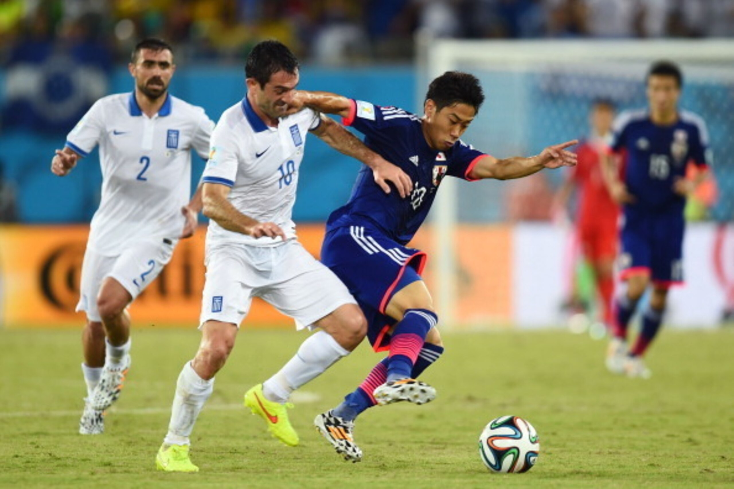 NATAL, BRAZIL - JUNE 19: Giorgos Karagounis of Greece challenges Shinji Kagawa of Japan during the 2014 FIFA World Cup Brazil Group C match between Japan and Greece at Estadio das Dunas on June 19, 2014 in Natal, Brazil. (Photo by Jamie McDonald/Getty I NATAL, BRAZIL - JUNE 19: Giorgos Karagounis of Greece challenges Shinji Kagawa of Japan during the 2014 FIFA World Cup Brazil Group C match between Japan and Greece at Estadio das Dunas on June 19, 2014 in Natal, Brazil. (Photo by Jamie McDonald/Getty I