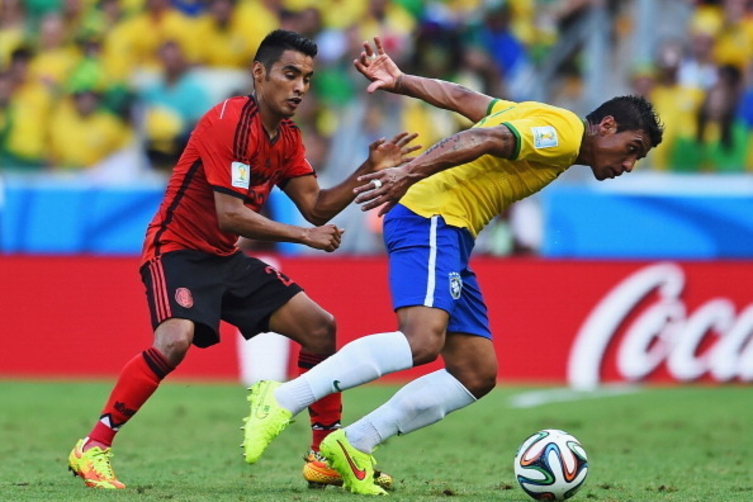 FORTALEZA, BRAZIL - JUNE 17:  Paulinho of Brazil and Jose Juan Vazquez of Mexico compete for the ball during the 2014 FIFA World Cup Brazil Group A match between Brazil and Mexico at Castelao on June 17, 2014 in Fortaleza, Brazil.  (Photo by Buda Mendes/G