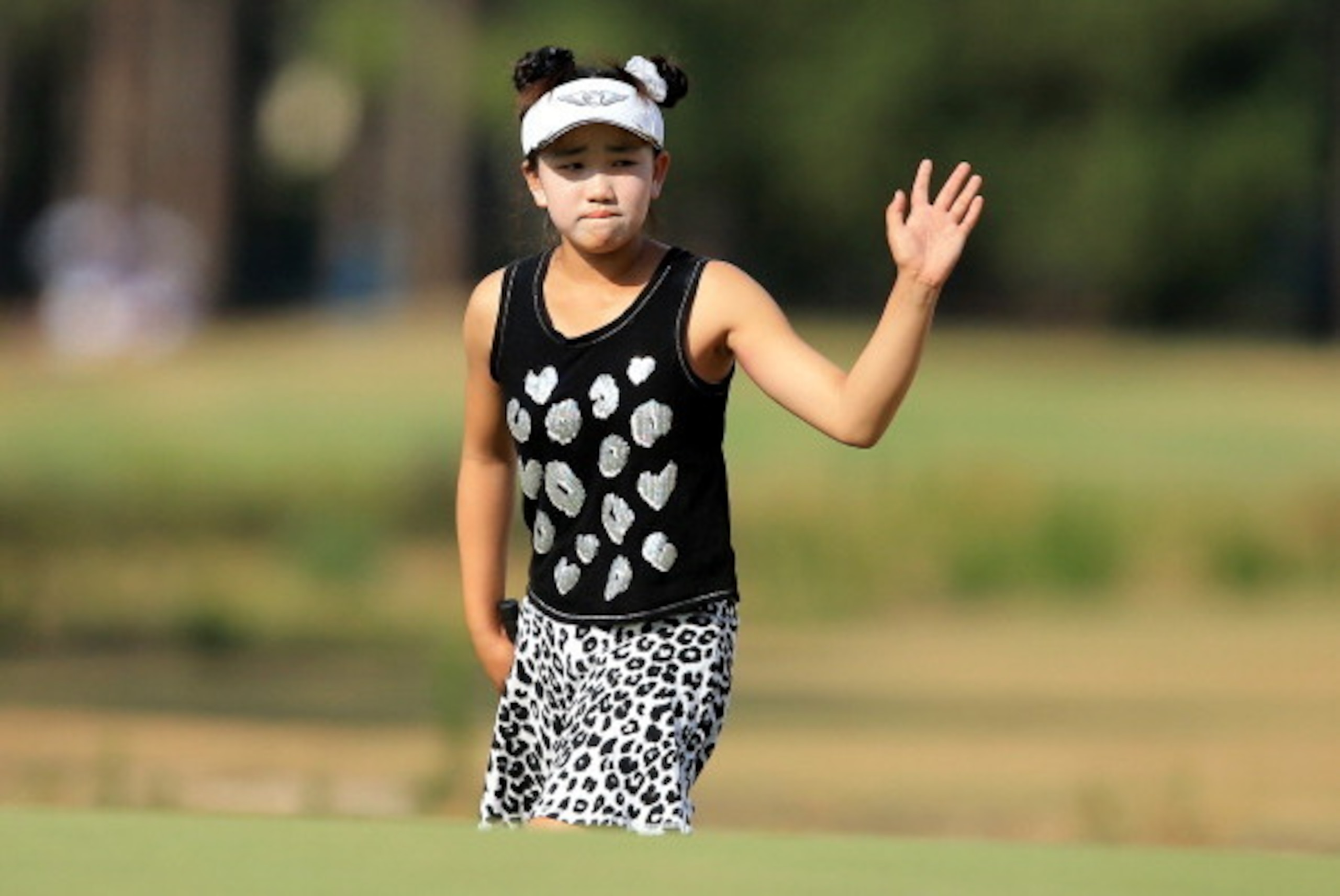 PINEHURST, NC - JUNE 20:  Lucy Li of the USA the 11 year old amateur acknowledges the crowd as she walks onto the green at the par 4, 18th hole during the second round of the 69th U.S. Women's Open at Pinehurst Resort & Country Club, Course No. 2, on June