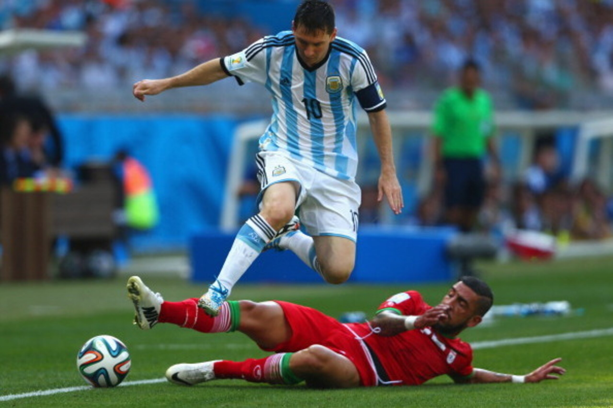 BELO HORIZONTE, BRAZIL - JUNE 21: Ashkan Dejagah of Iran tackles Lionel Messi of Argentina during the 2014 FIFA World Cup Brazil Group F match between Argentina and Iran at Estadio Mineirao on June 21, 2014 in Belo Horizonte, Brazil.  (Photo by Quinn Roon