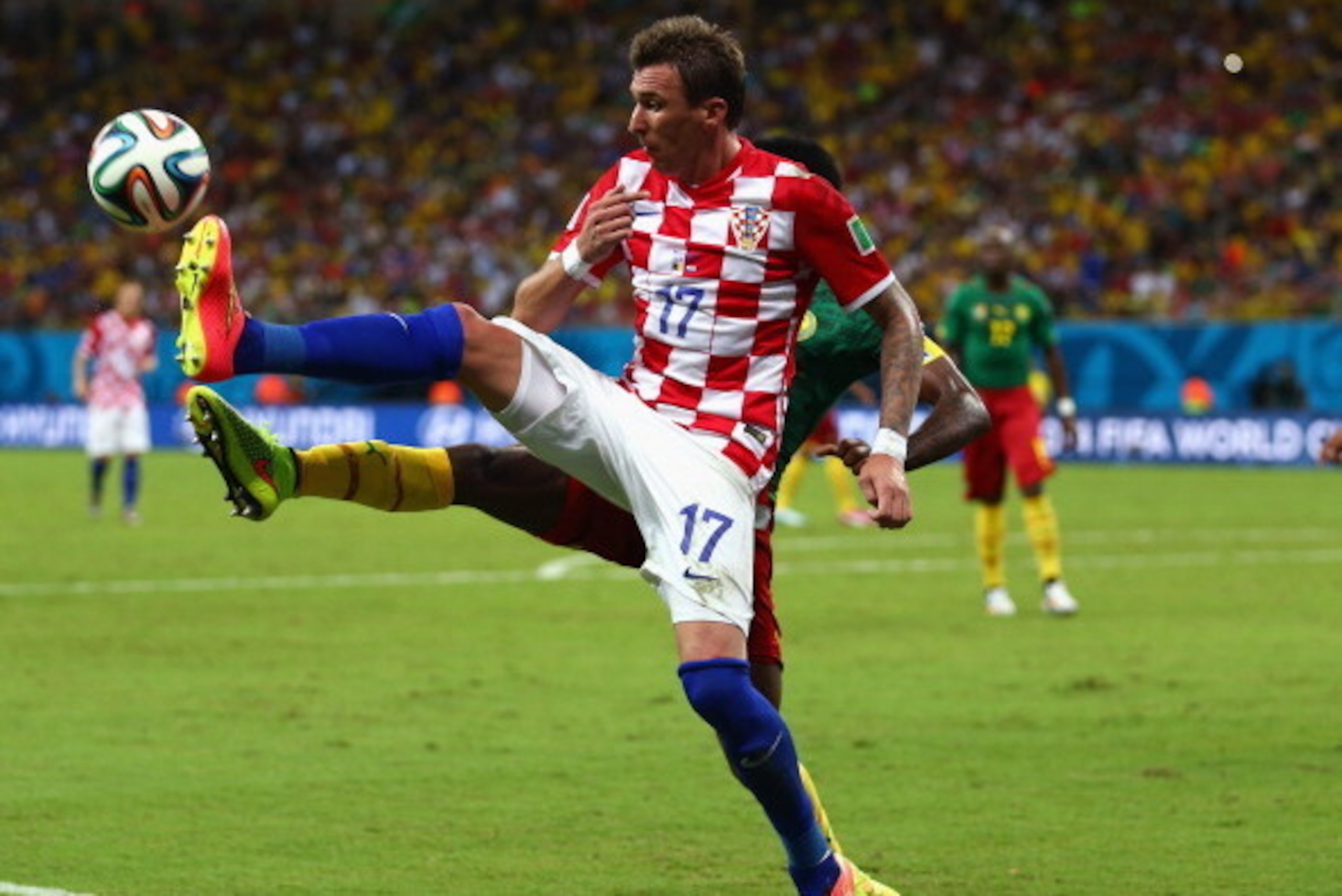 MANAUS, BRAZIL - JUNE 18:  Mario Mandzukic of Croatia controls the ball as Nicolas N'Koulou of Cameroon gives chase during the 2014 FIFA World Cup Brazil Group A match between Cameroon and Croatia at Arena Amazonia on June 18, 2014 in Manaus, Brazil.  (Ph