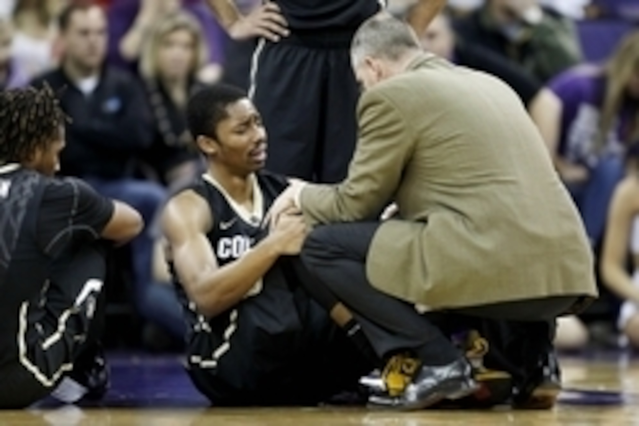 Jan 12, 2014; Seattle, WA, USA; Colorado Buffaloes guard Spencer Dinwiddie (25) is consoled by head coach Tad Boyle after suffering an injury during the first half against the Washington Huskies at Alaska Airlines Arena at Hec Edmundson Pavilion. Mandator