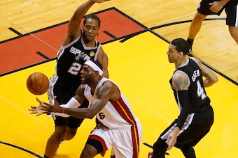 Jun 10, 2014; Miami, FL, USA; Miami Heat forward LeBron James (6) loses control of the ball while being guarded by San Antonio Spurs forward Kawhi Leonard (2) and guard Danny Green (4) during the first quarter of game three of the 2014 NBA Finals at Ameri