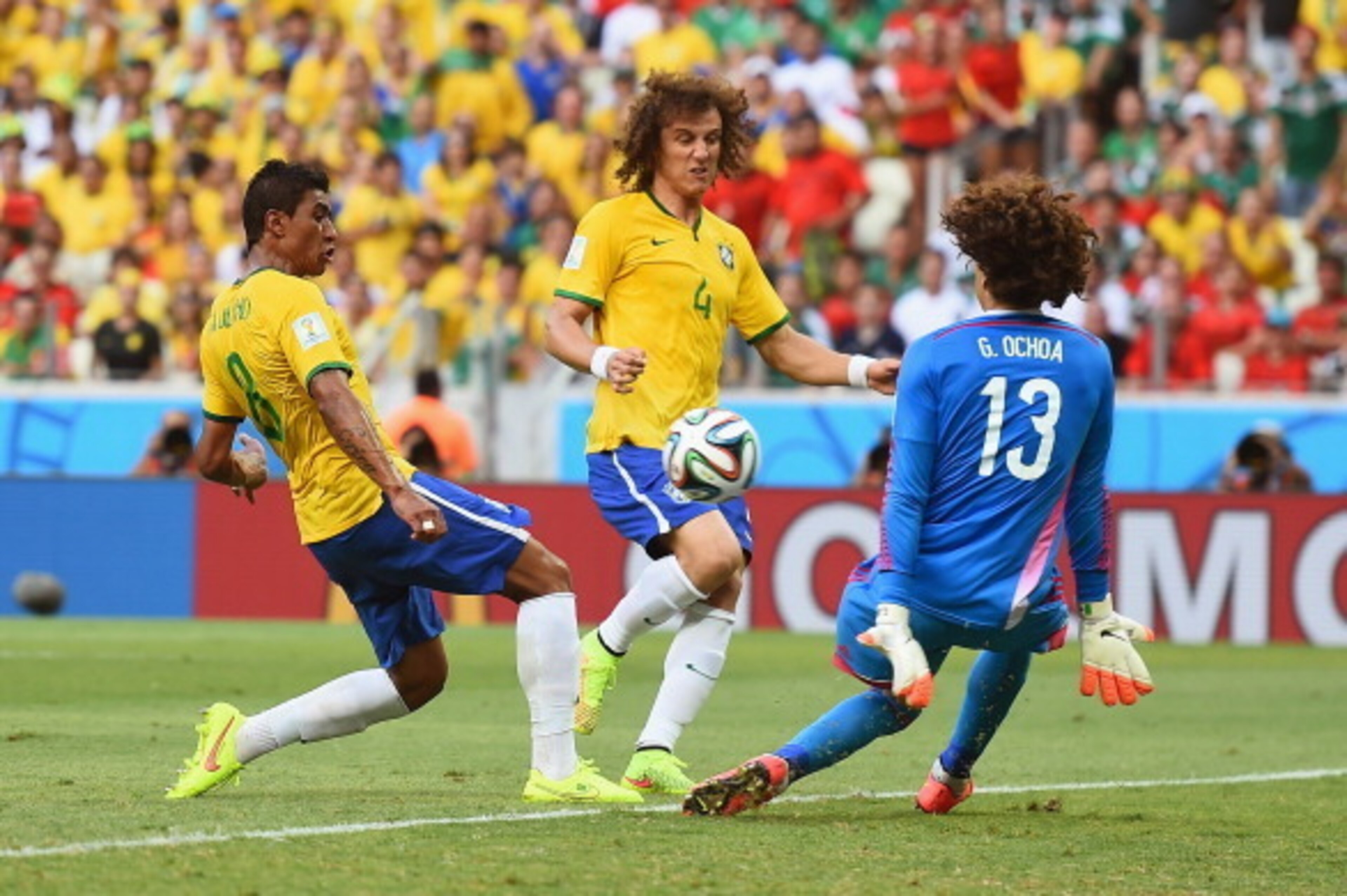 FORTALEZA, BRAZIL - JUNE 17: Paulinho of Brazil shoots against Guillermo Ochoa of Mexico as David Luiz runs on during the 2014 FIFA World Cup Brazil Group A match between Brazil and Mexico at Castelao on June 17, 2014 in Fortaleza, Brazil. (Photo by Lau FORTALEZA, BRAZIL - JUNE 17: Paulinho of Brazil shoots against Guillermo Ochoa of Mexico as David Luiz runs on during the 2014 FIFA World Cup Brazil Group A match between Brazil and Mexico at Castelao on June 17, 2014 in Fortaleza, Brazil. (Photo by Lau