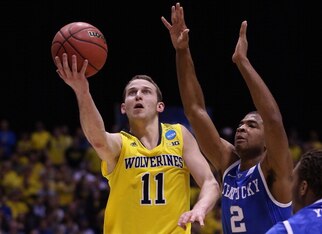 INDIANAPOLIS, IN - MARCH 30:  Nik Stauskas #11 of the Michigan Wolverines shoots the ball against Aaron Harrison #2 of the Kentucky Wildcats during the midwest regional final of the 2014 NCAA Men's Basketball Tournament at Lucas Oil Stadium on March 30, 2