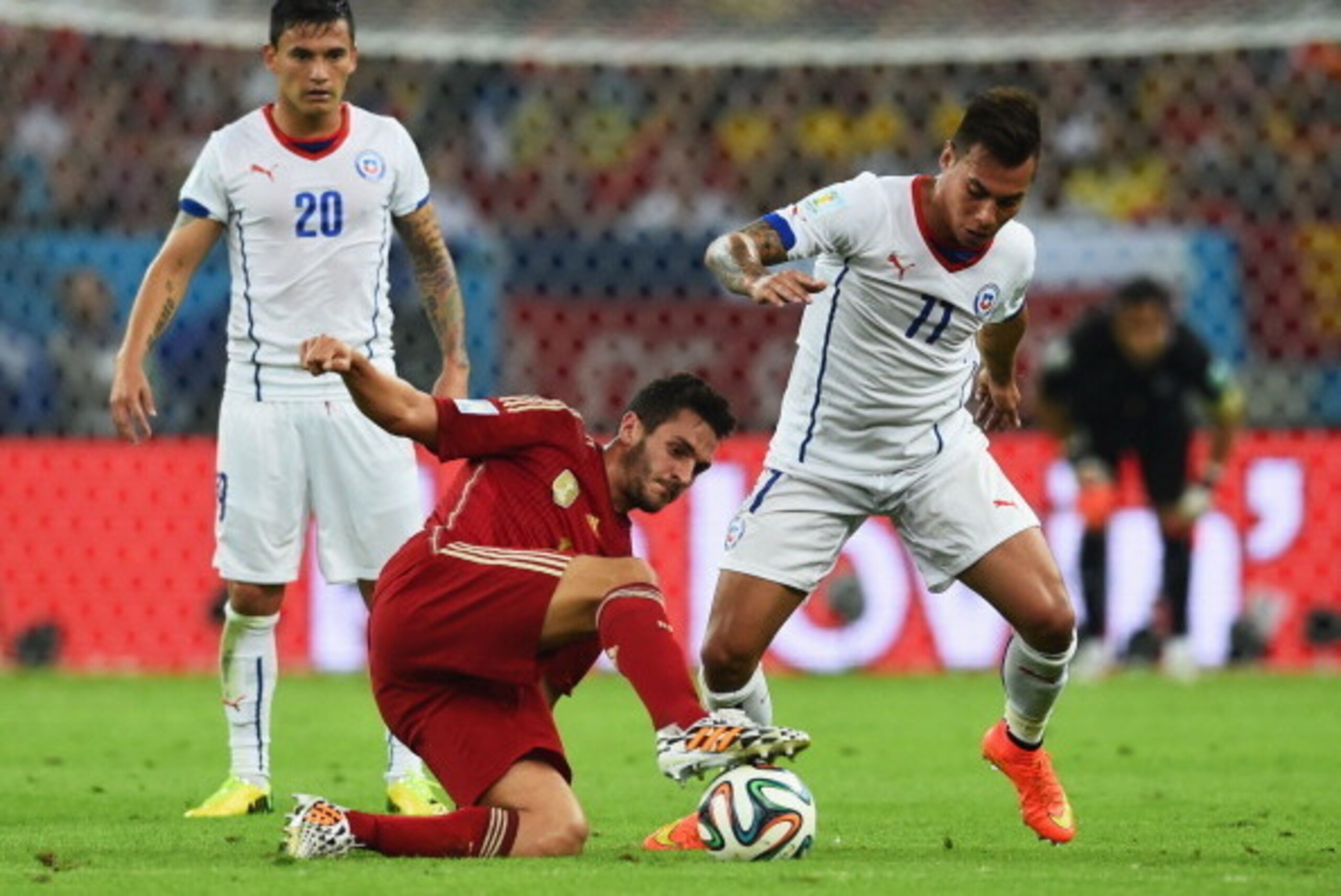 RIO DE JANEIRO, BRAZIL - JUNE 18:  Koke of Spain takes on Charles Aranguiz (L) and Eduardo Vargas of Chile (R) during the 2014 FIFA World Cup Brazil Group B match between Spain and Chile at Maracana on June 18, 2014 in Rio de Janeiro, Brazil.  (Photo by M