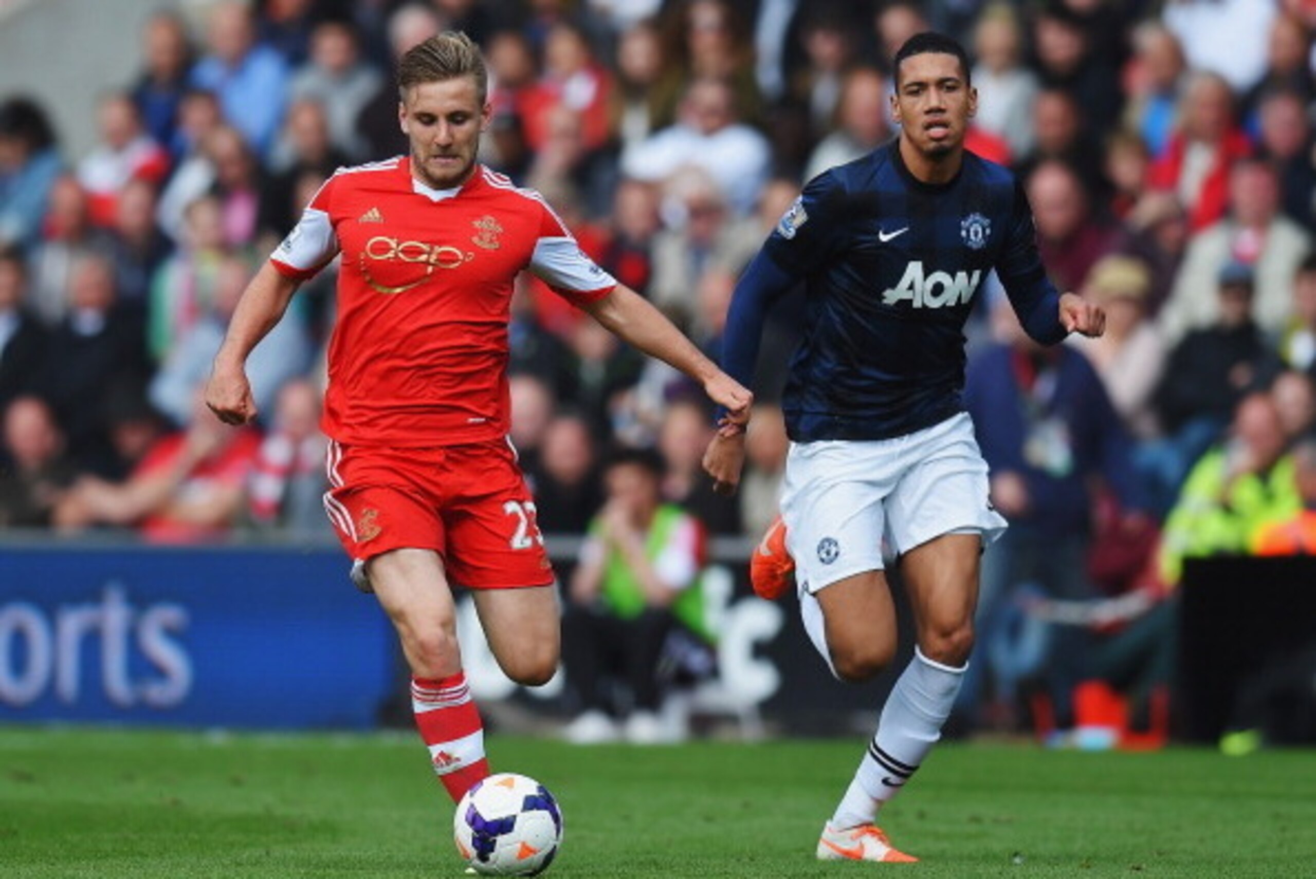 SOUTHAMPTON, ENGLAND - MAY 11:  (L-R) Luke Shaw of Southampton holds off Chris Smalling of Manchester United during the Barclays Premier League match between Southampton and Manchester United at St Mary's Stadium on May 11, 2014 in Southampton, England.  