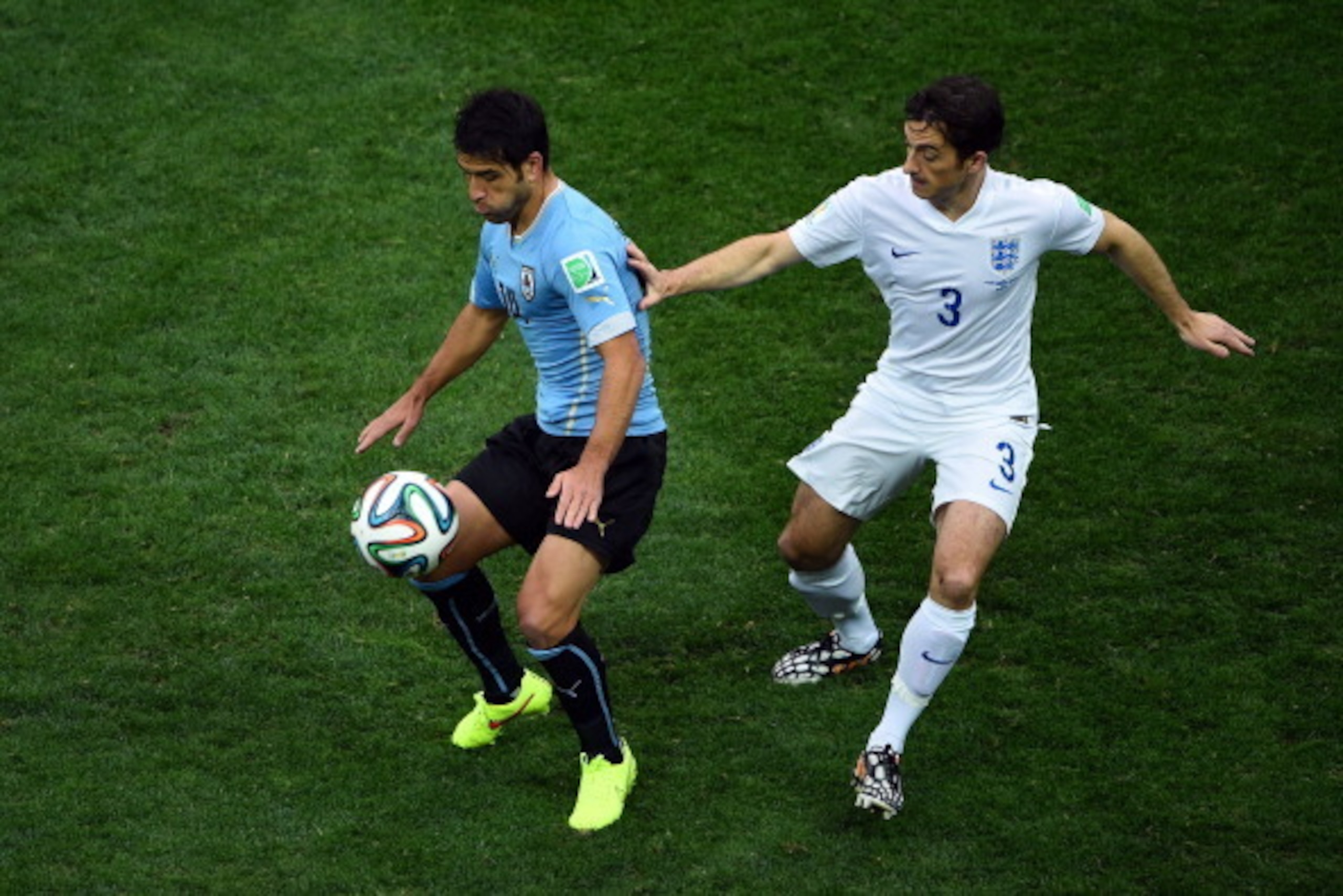 SAO PAULO, BRAZIL - JUNE 19:  Nicolas Lodeiro of Uruguay controls the ball as Leighton Baines of England gives chase during the 2014 FIFA World Cup Brazil Group D match between Uruguay and England at Arena de Sao Paulo on June 19, 2014 in Sao Paulo, Brazi