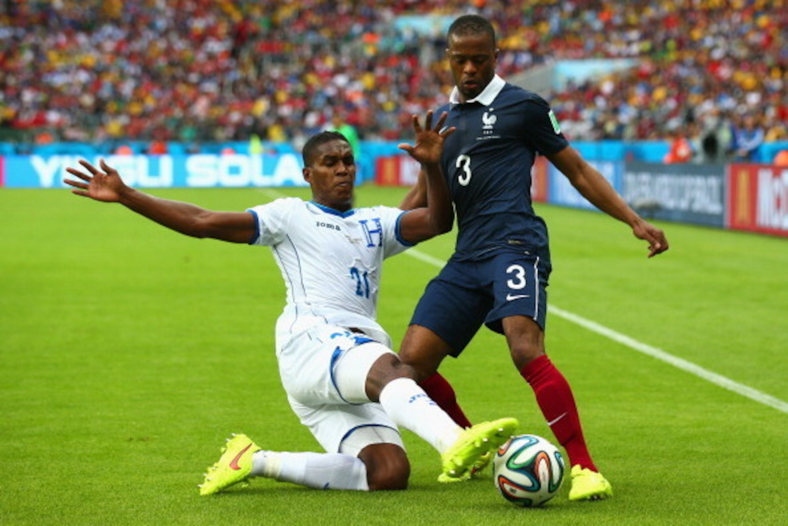 PORTO ALEGRE, BRAZIL - JUNE 15:  Brayan Beckeles of Honduras challenges Patrice Evra of France during the 2014 FIFA World Cup Brazil Group E match between France and Honduras at Estadio Beira-Rio on June 15, 2014 in Porto Alegre, Brazil.  (Photo by Ian Wa