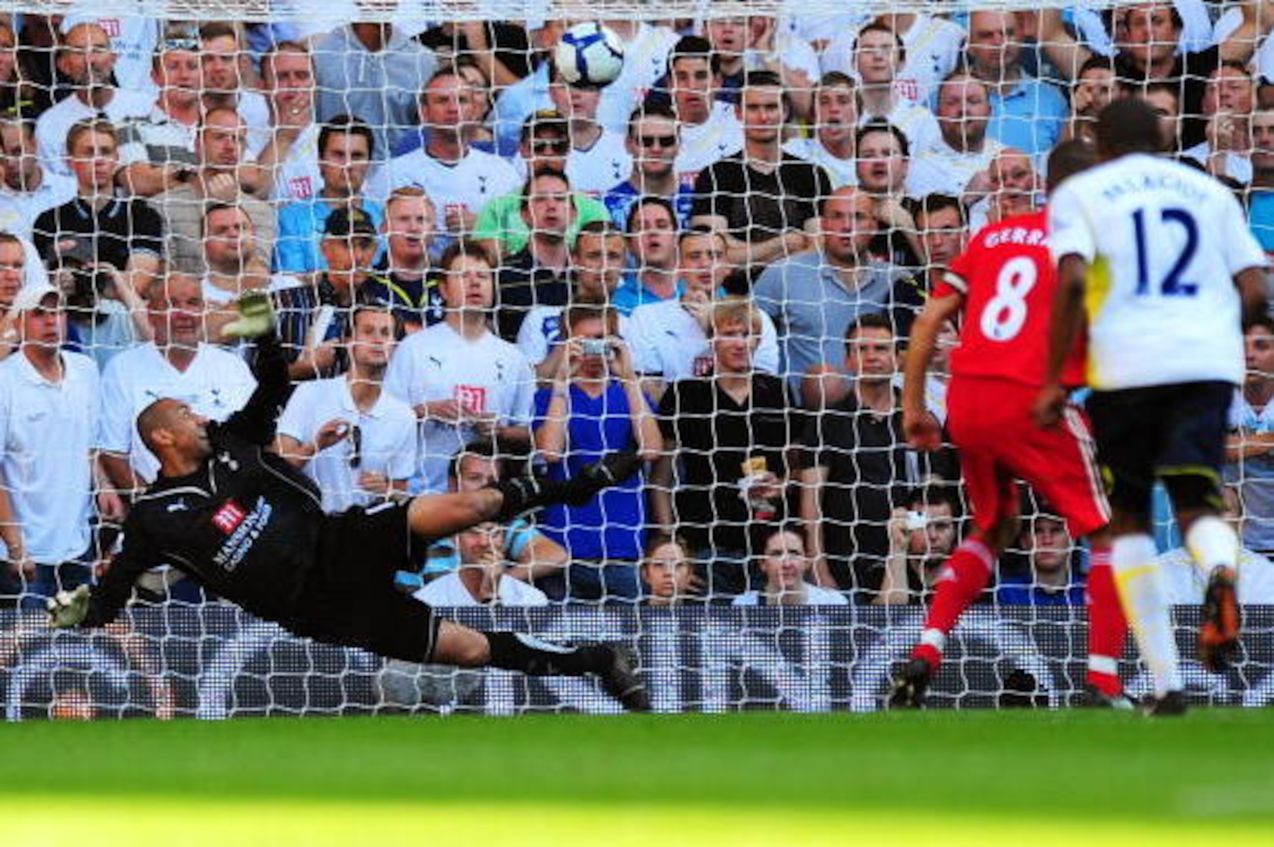 LONDON, ENGLAND - AUGUST 16:  Steven Gerrard #8 (obscured) of Liverpool scores from the penalty spot past Heurelho Gomes of Tottenham to level the scores at 1-1 during the Barclays Premier League match between Tottenham Hotspur and Liverpool at White Hart