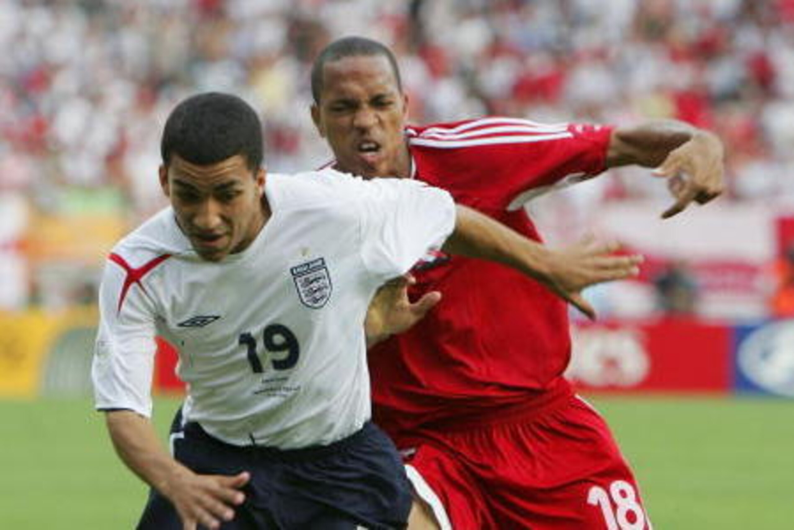 NUREMBERG, GERMANY - JUNE 15:  Aaron Lennon of England is challenged by Densill Theobald of Trinidad and Tobago during the FIFA World Cup Germany 2006 Group B match between England and Trinidad and Tobago at the Frankenstadion on June 15, 2006 in Nurember