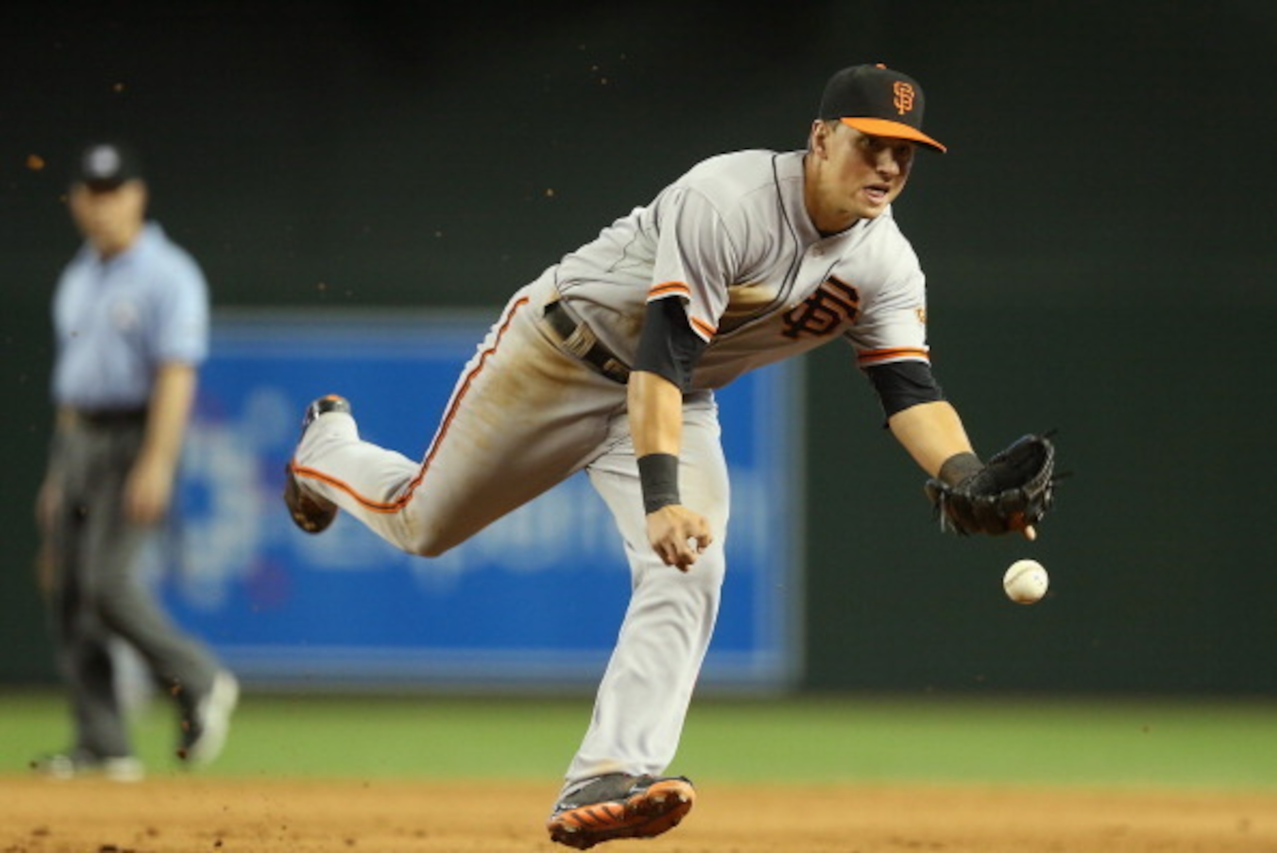 PHOENIX, AZ - JUNE 22:  Infielder Joe Panik #12 of the San Francisco Giants flips the ball to first base for a ground ball out against the Arizona Diamondbacks during the fifth inning of the MLB game at Chase Field on June 22, 2014 in Phoenix, Arizona.  (