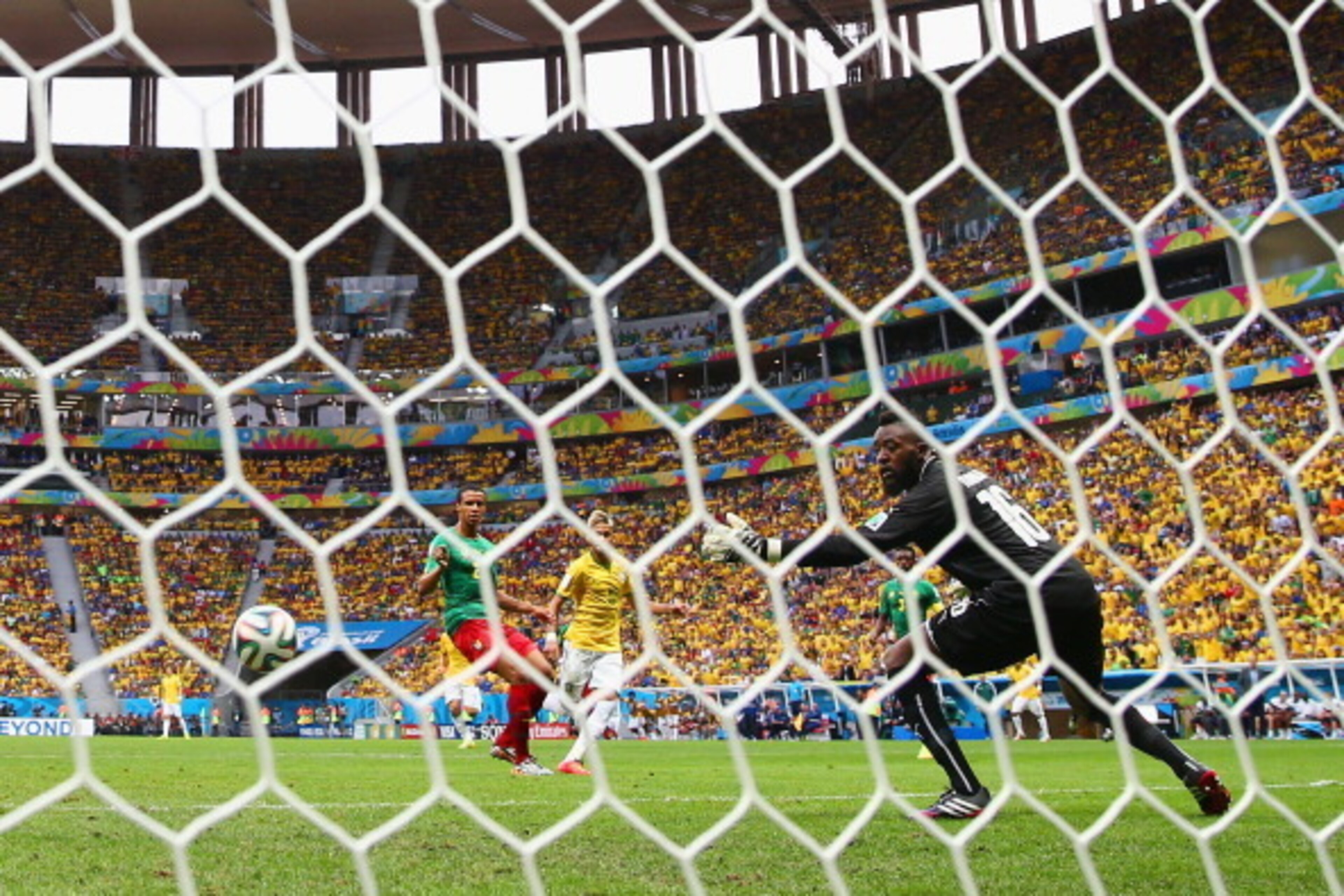 BRASILIA, BRAZIL - JUNE 23: Neymar of Brazil scores his team's first goal past Charles Itandje of Cameroon during the 2014 FIFA World Cup Brazil Group A match between Cameroon and Brazil at Estadio Nacional on June 23, 2014 in Brasilia, Brazil.  (Photo by