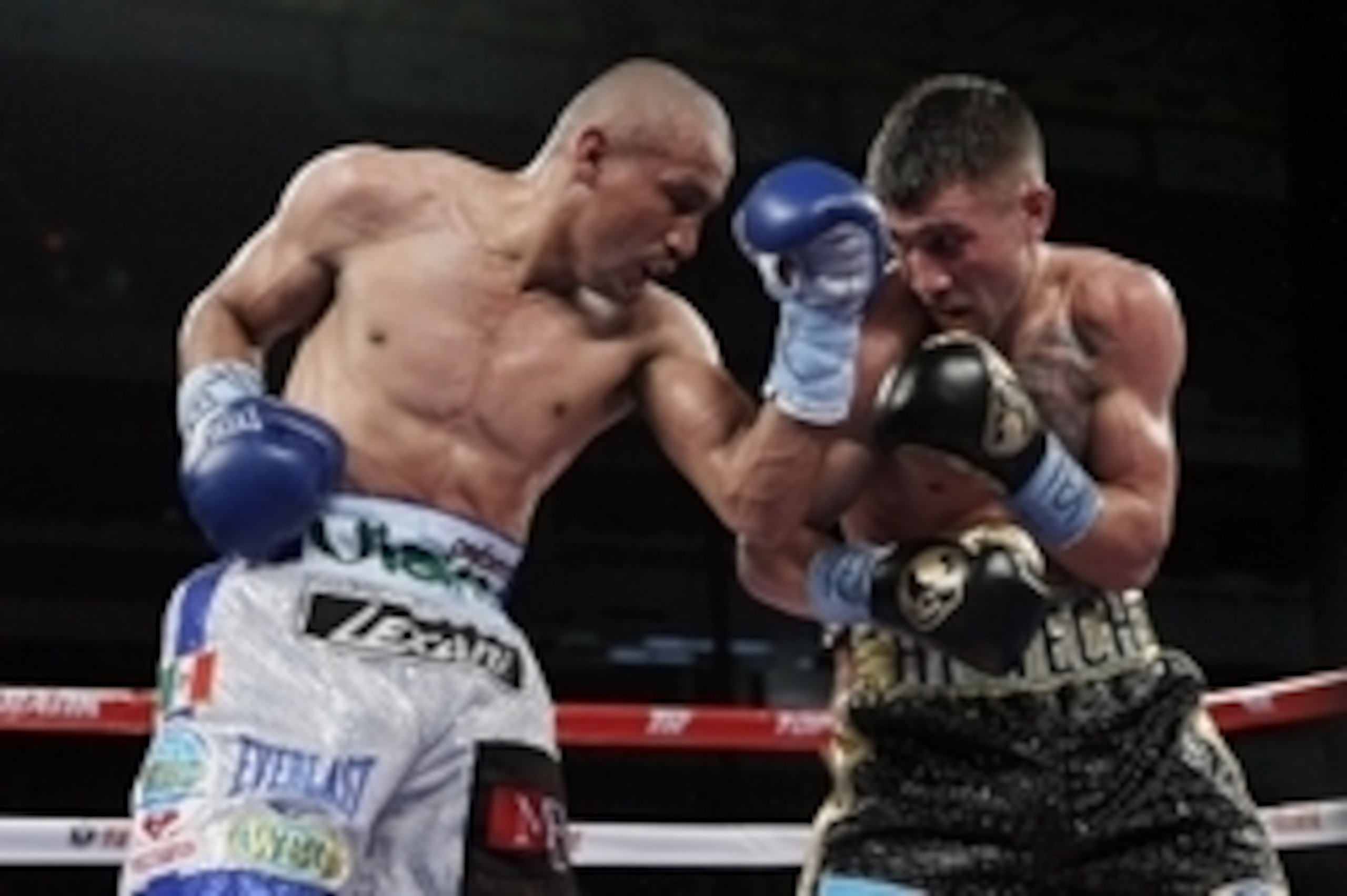 Mar 1, 2014; San Antonio, TX, USA; Orlando Salido (white trunks) trades punches with Vasyl Lomachenko (black trunks) during their WBO world featherweight title bout at Alamodome. Mandatory Credit: Soobum Im-USA TODAY Sports