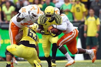 EUGENE, OR - SEPTEMBER 14:  Byron Marshall #9 of the Oregon Ducks runs the ball as A.J. Johnson #45 and Trevarris Saulsberry #96 of the Tennessee Volunteers move in for the tackle on September 14, 2013 at the Autzen Stadium in Eugene, Oregon.  (Photo by J
