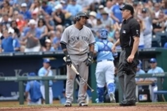 Jun 8, 2014; Kansas City, MO, USA; New York Yankees second basemen Yangervis Solarte (26) reacts to being call out on strikes to home plate umpire Mike DiMuro (R) to end the top of the third inning against the Kansas City Royals at Kauffman Stadium. The R