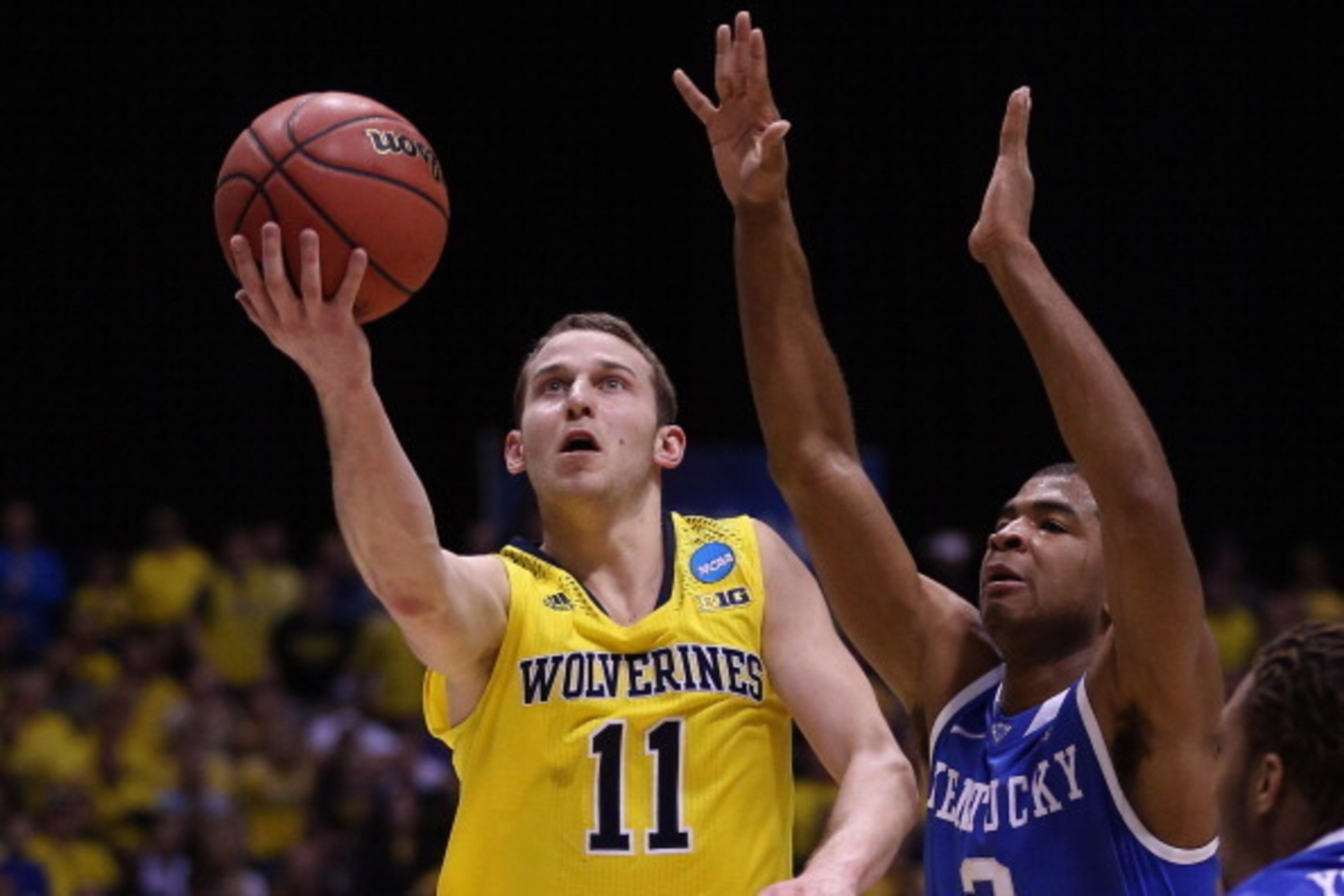 INDIANAPOLIS, IN - MARCH 30:  Nik Stauskas #11 of the Michigan Wolverines shoots the ball against Aaron Harrison #2 of the Kentucky Wildcats during the midwest regional final of the 2014 NCAA Men's Basketball Tournament at Lucas Oil Stadium on March 30, 2