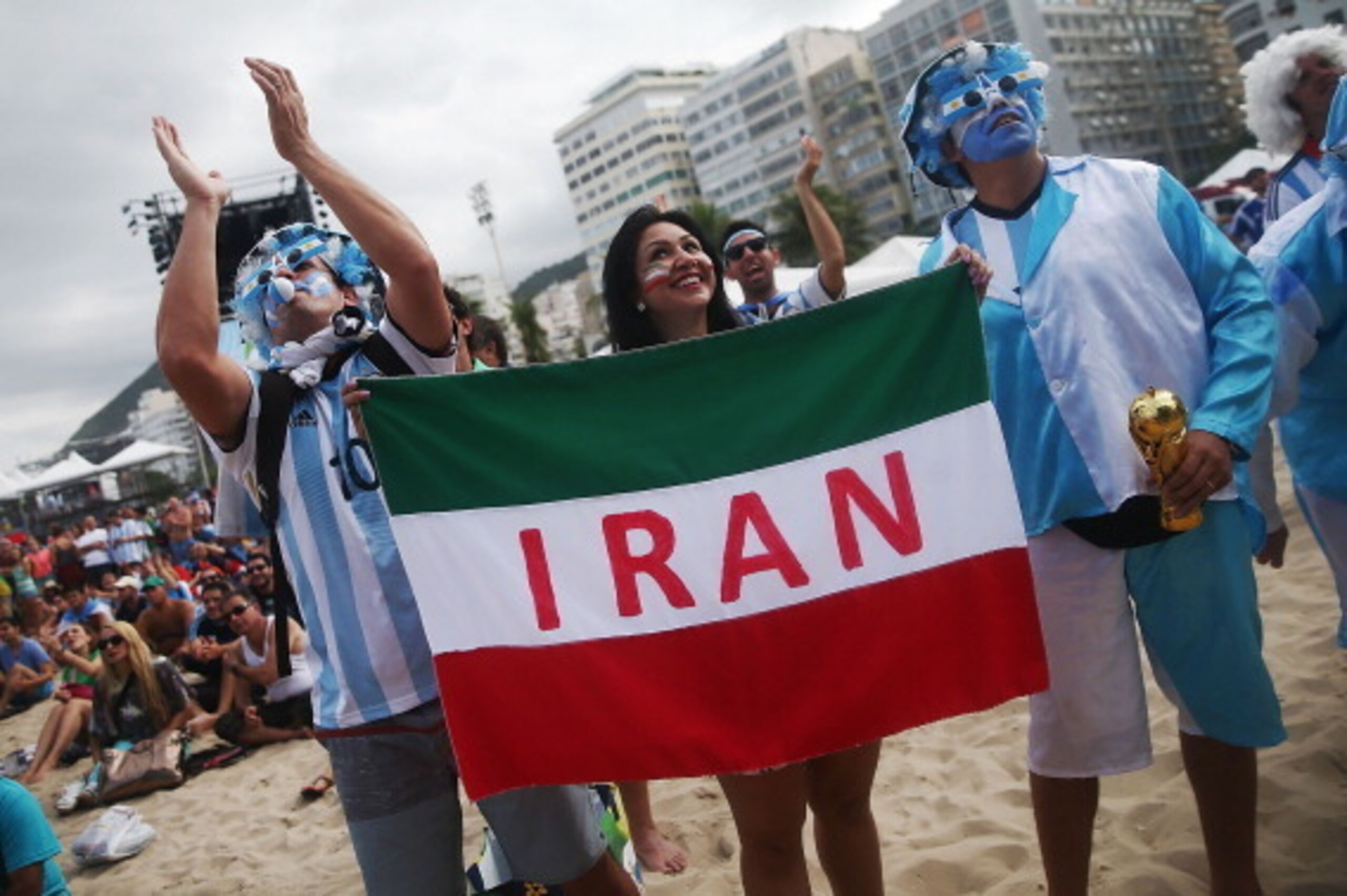 RIO DE JANEIRO, BRAZIL - JUNE 21: Argentina fans pose next to an Iranian supporter (C) before Iran lost to Argentina while watching at FIFA Fan Fest on June 21, 2014 in Rio de Janeiro, Brazil. Argentina defeated Iran 1-0 on the tenth day of the 2014 FIFA RIO DE JANEIRO, BRAZIL - JUNE 21: Argentina fans pose next to an Iranian supporter (C) before Iran lost to Argentina while watching at FIFA Fan Fest on June 21, 2014 in Rio de Janeiro, Brazil. Argentina defeated Iran 1-0 on the tenth day of the 2014 FIFA