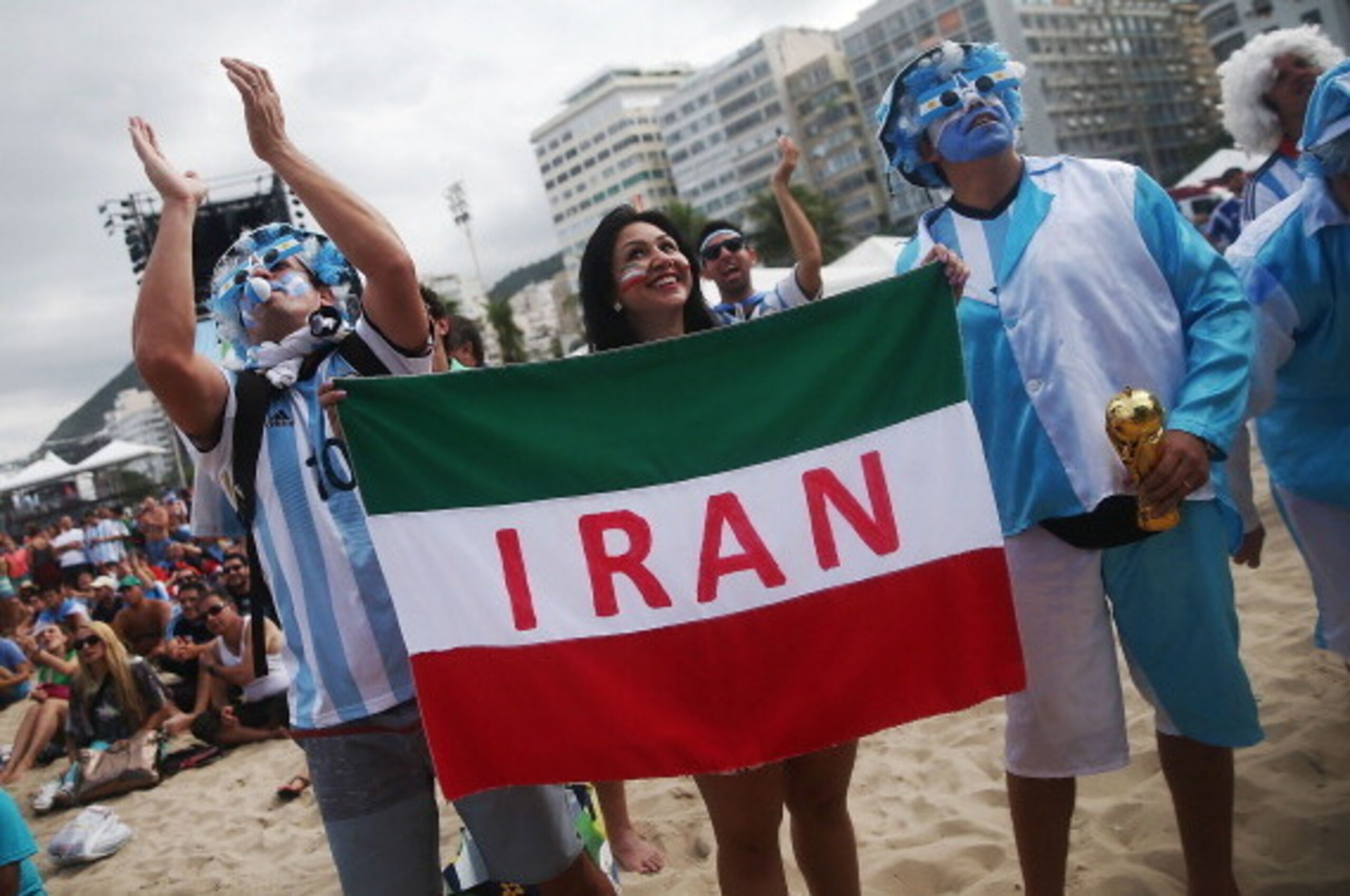 RIO DE JANEIRO, BRAZIL - JUNE 21: Argentina fans pose next to an Iranian supporter (C) before Iran lost to Argentina while watching at FIFA Fan Fest on June 21, 2014 in Rio de Janeiro, Brazil. Argentina defeated Iran 1-0 on the tenth day of the 2014 FIFA RIO DE JANEIRO, BRAZIL - JUNE 21: Argentina fans pose next to an Iranian supporter (C) before Iran lost to Argentina while watching at FIFA Fan Fest on June 21, 2014 in Rio de Janeiro, Brazil. Argentina defeated Iran 1-0 on the tenth day of the 2014 FIFA