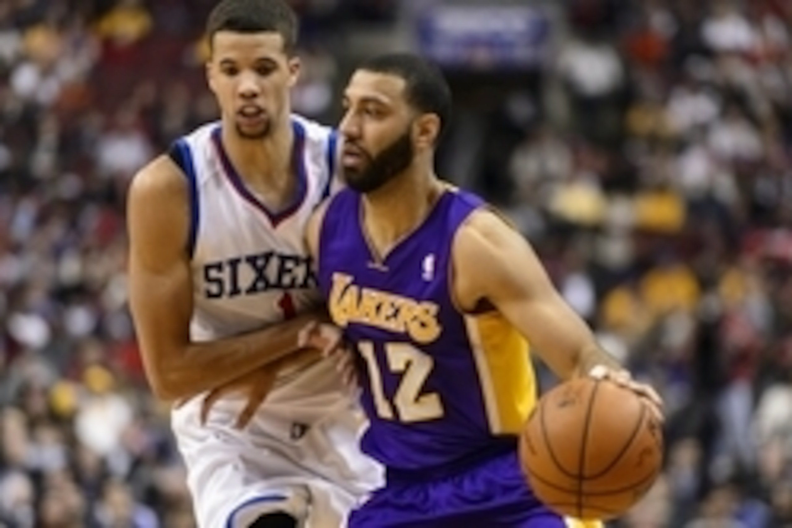 Feb 7, 2014; Philadelphia, PA, USA; Los Angeles Lakers guard Kendall Marshall (12) is defended by Philadelphia 76ers guard Michael Carter-Williams (1) during the fourth quarter at the Wells Fargo Center. The Lakers defeated the Sixers 112-98. Mandatory Cr