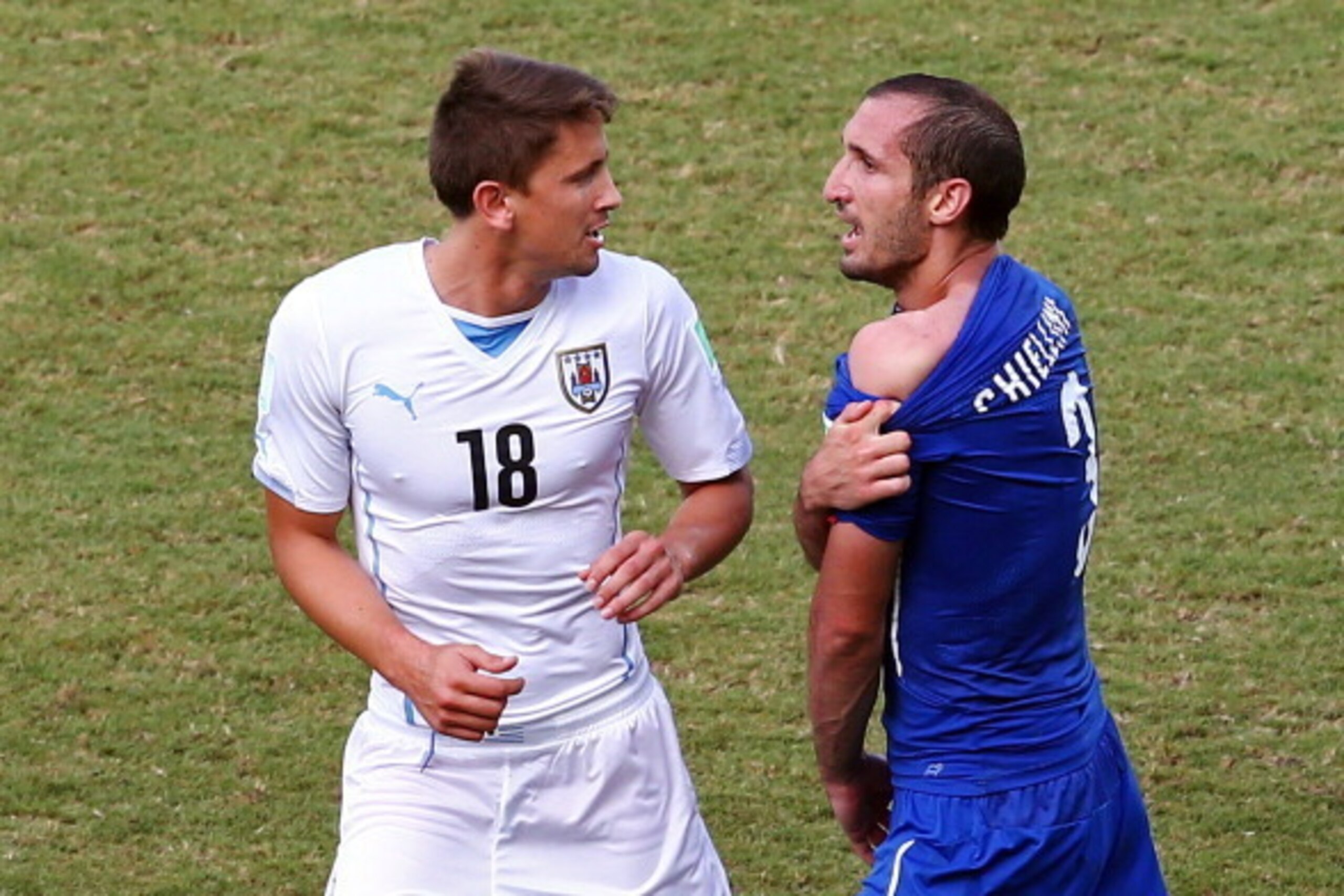 NATAL, BRAZIL - JUNE 24:  Giorgio Chiellini of Italy pulls down his shirt after a clash with Luis Suarez of Uruguay (not pictured) as Gaston Ramirez of Uruguay looks on during the 2014 FIFA World Cup Brazil Group D match between Italy and Uruguay at Estad