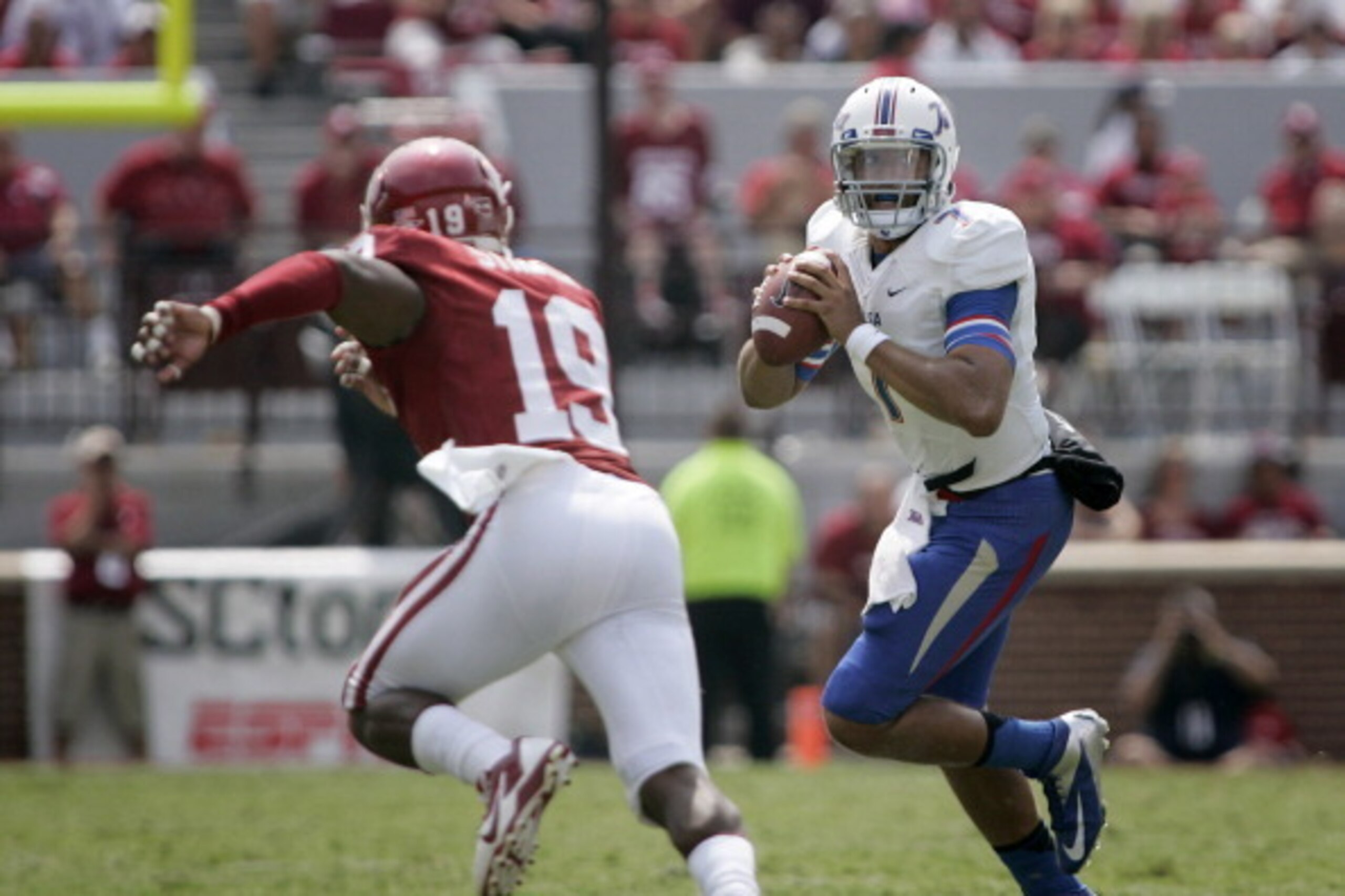 NORMAN, OK - SEPTEMBER 14:   Quarterback Cody Green #7 of the Tulsa Golden Hurricane looks to throw under pressure from linebacker Eric Striker #19 of the Oklahoma Sooners September 14, 2013 at Gaylord Family-Oklahoma Memorial Stadium in Norman, Oklahoma.