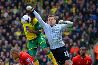NORWICH, ENGLAND - APRIL 20:  Simon Mignolet of Liverpool fails to punch the ball clear during the Barclays Premier League match between Norwich City and Liverpool at Carrow Road on April 20, 2014 in Norwich, England.  (Photo by Michael Regan/Getty Images