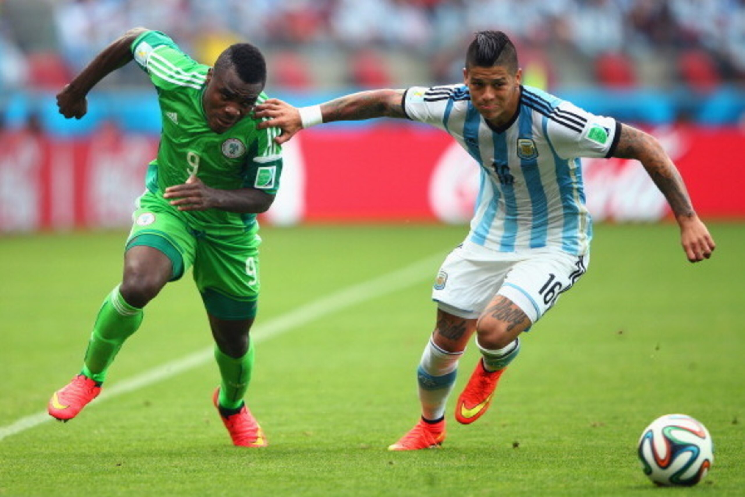 PORTO ALEGRE, BRAZIL - JUNE 25: Marcos Rojo of Argentina competes for the ball with Emmanuel Emenike of Nigeria during the 2014 FIFA World Cup Brazil Group F match between Nigeria and Argentina at Estadio Beira-Rio on June 25, 2014 in Porto Alegre, Brazil
