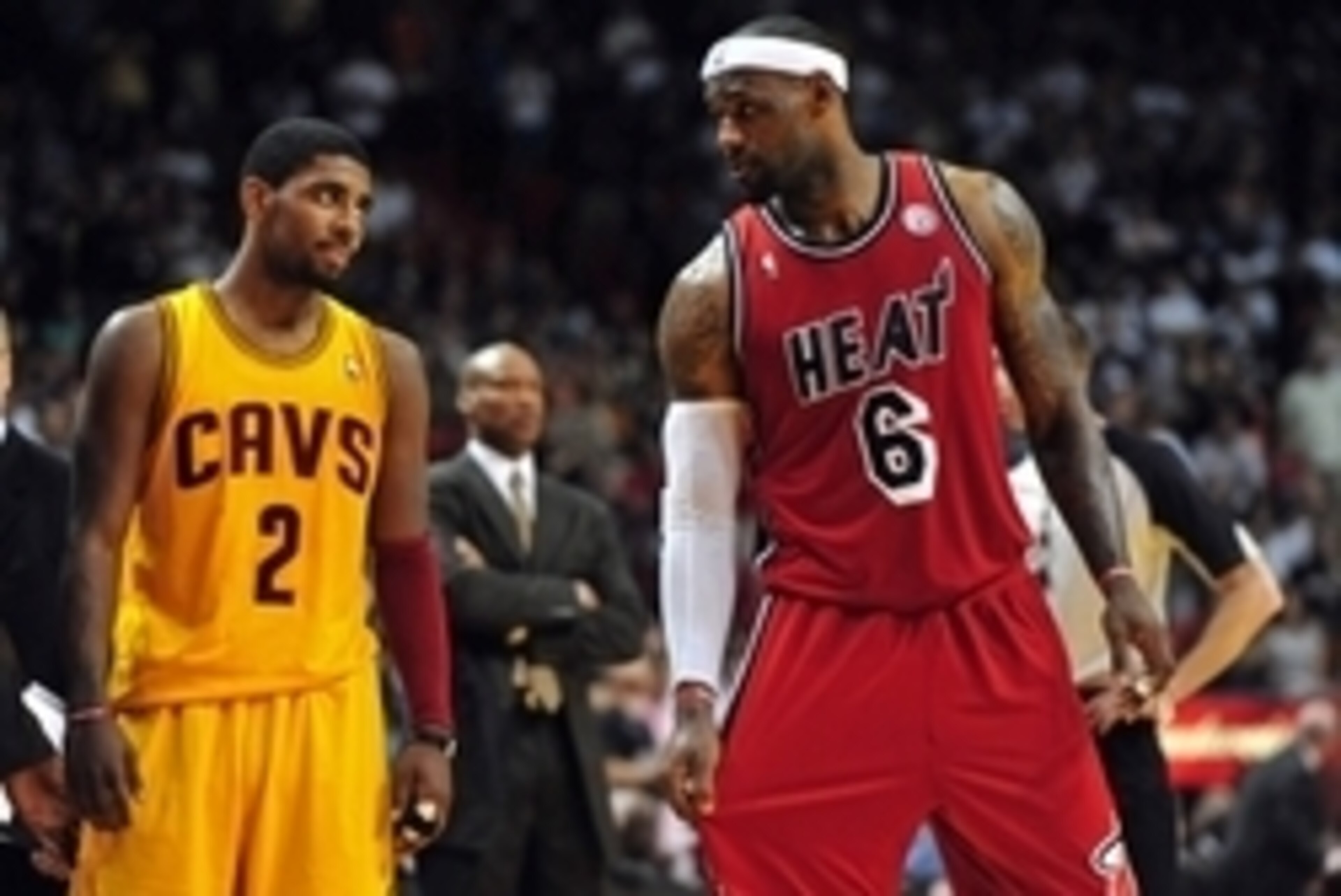 Feb 24, 2013; Miami, FL, USA; Cleveland Cavaliers point guard Kyrie Irving (left) looks over at Miami Heat small forward LeBron James (right) as Cleveland Cavaliers head coach Byron Scott (center) looks on during the second half at the American Airlines A