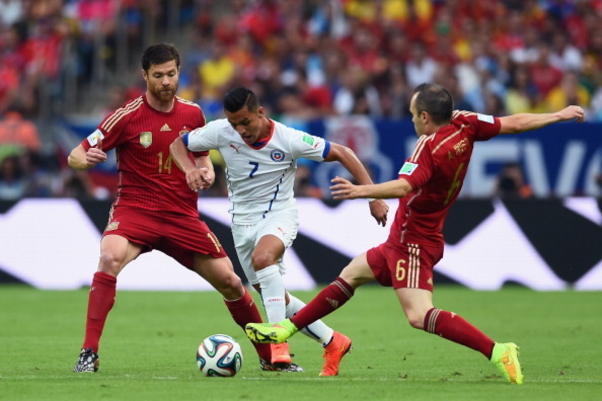 RIO DE JANEIRO, BRAZIL - JUNE 18:  Alexis Sanchez of Chile controls the ball against Xabi Alonso (L) and Andres Iniesta of Spain during the 2014 FIFA World Cup Brazil Group B match between Spain and Chile at Maracana on June 18, 2014 in Rio de Janeiro, Br