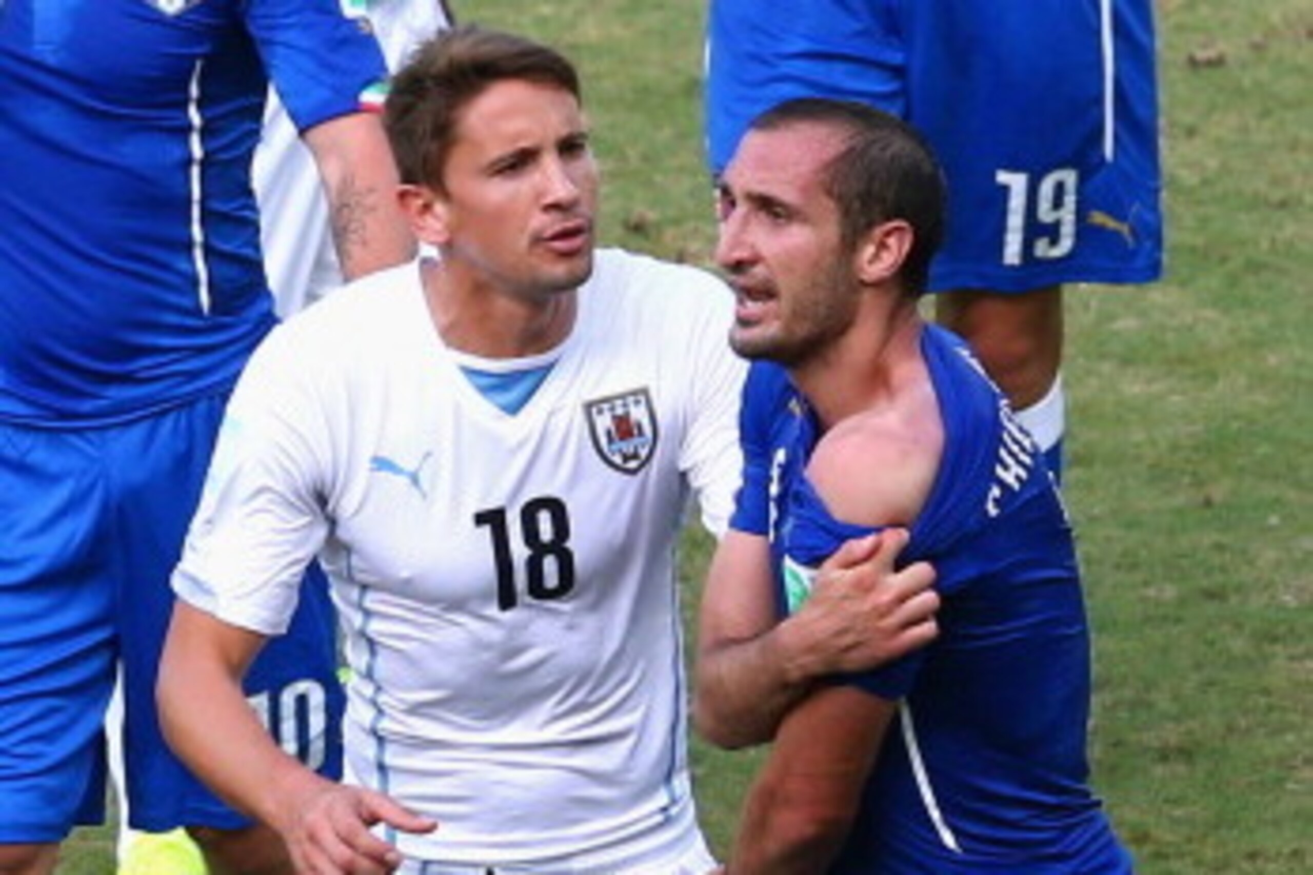 NATAL, BRAZIL - JUNE 24:  Giorgio Chiellini of Italy pulls down his shirt after a clash with Luis Suarez of Uruguay (not pictured) as Gaston Ramirez of Uruguay looks on during the 2014 FIFA World Cup Brazil Group D match between Italy and Uruguay at Estad