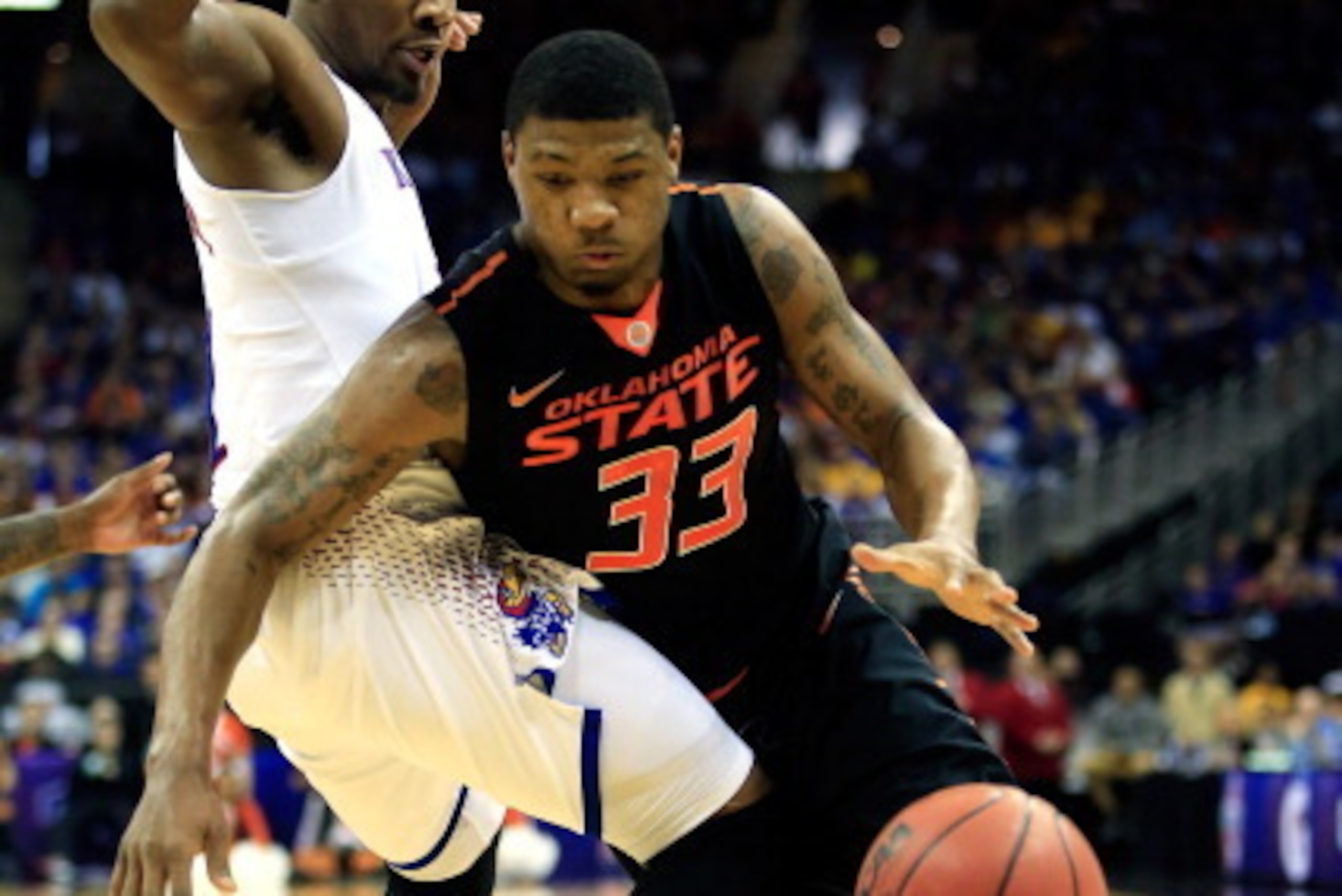 KANSAS CITY, MO - MARCH 13:  Marcus Smart #33 of the Oklahoma State Cowboys drives as Wayne Selden, Jr. #1 of the Kansas Jayhawks defends during the Big 12 Basketball Tournament quarterfinal game at Sprint Center on March 13, 2014 in Kansas City, Missouri